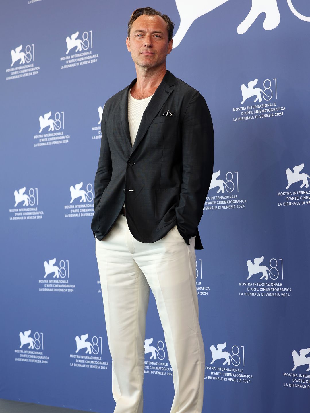 Jude Law in a black jacket and cream trousers