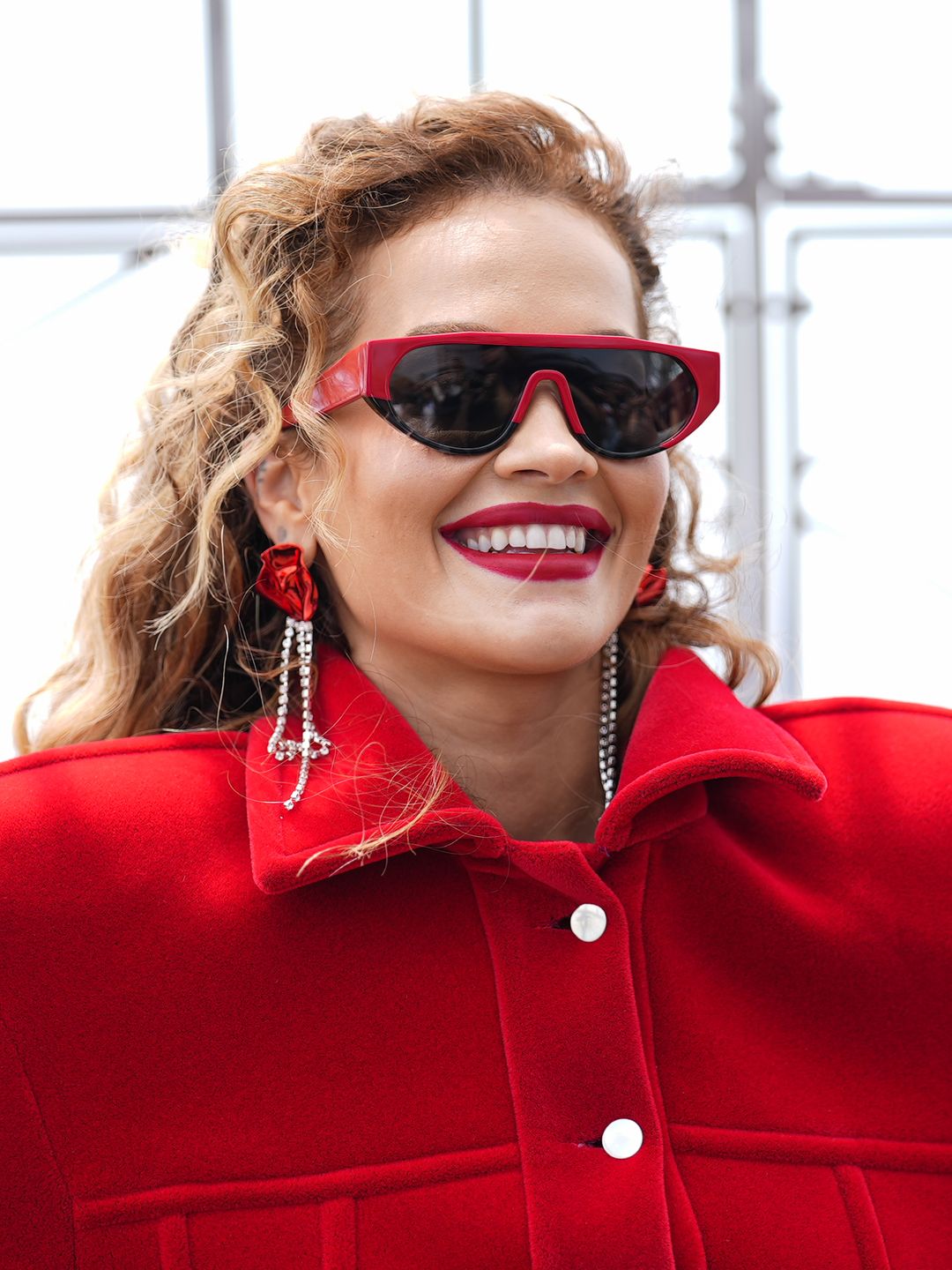 Rita Ora visits the Empire State Building in a red dress, sunglasses and earings