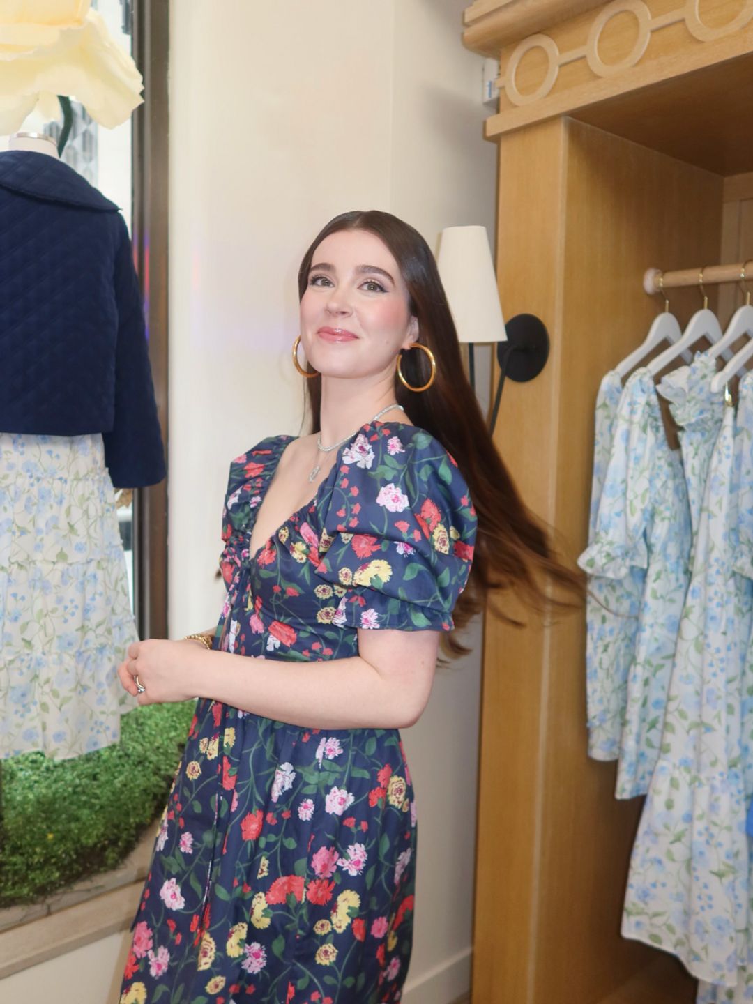 Nell Diamond poses in a blue floral summer dress