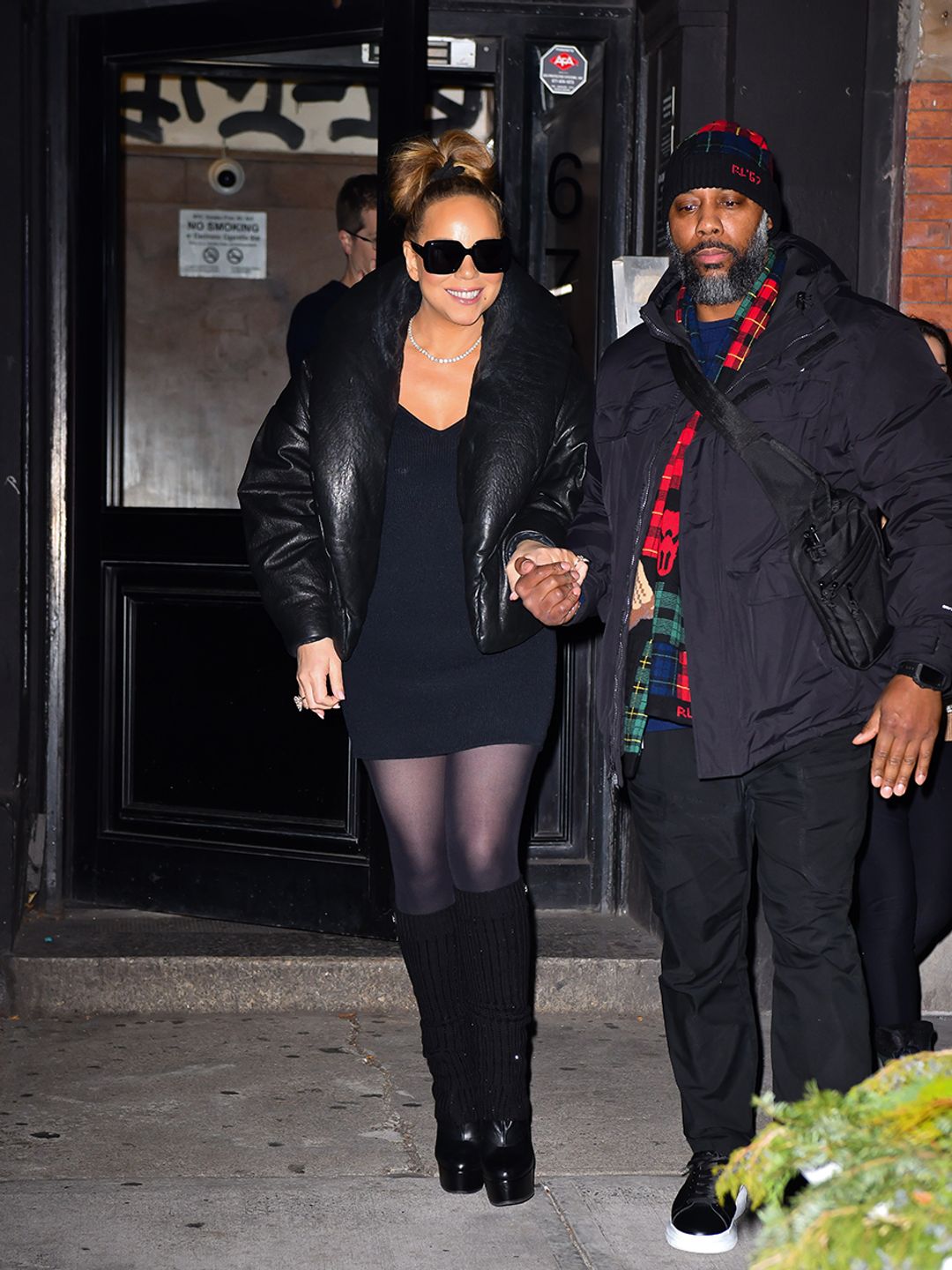 Mariah Carey wearing a black dress and puffer coat in Manhattan. 