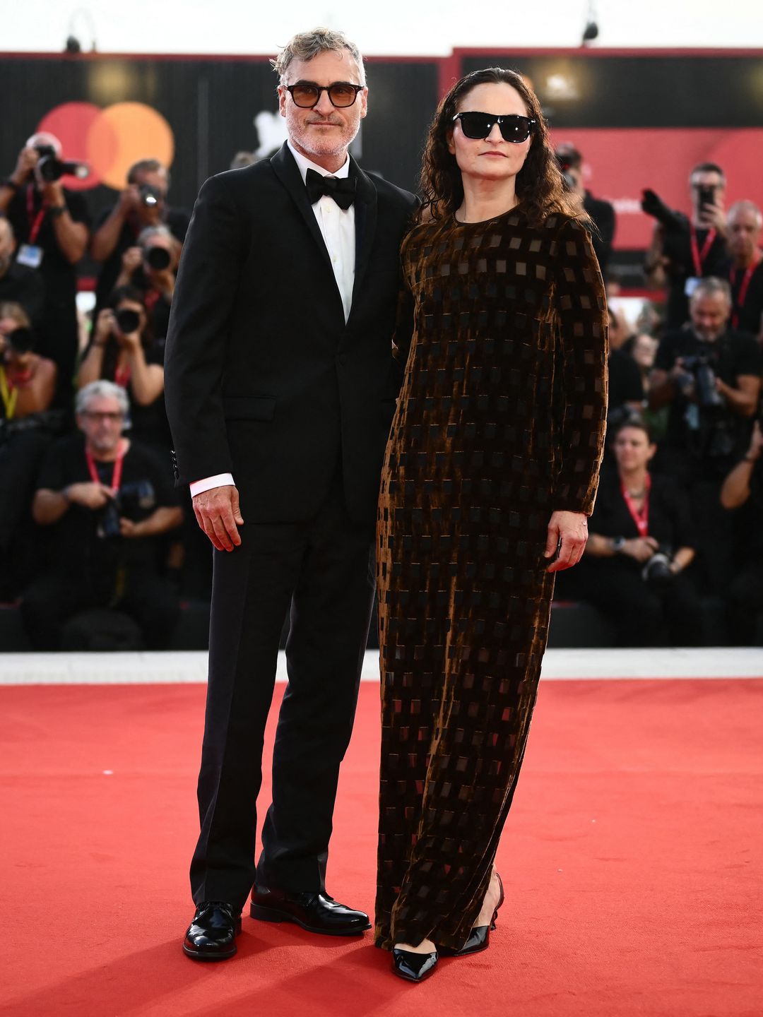 Joaquin Phoenix in a tuxedo and Rain Phoenix in a bodysuit