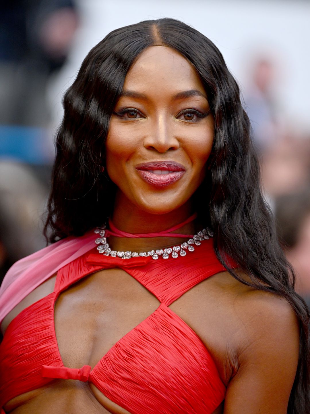 Naomi Campbell wearing a red dress with softly waved hair 