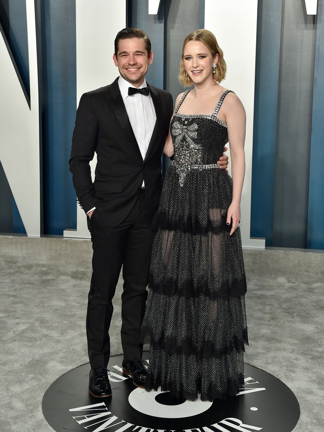 Jason Ralph and Rachel Brosnahan pose on carpet at Vanity Fair Oscars party