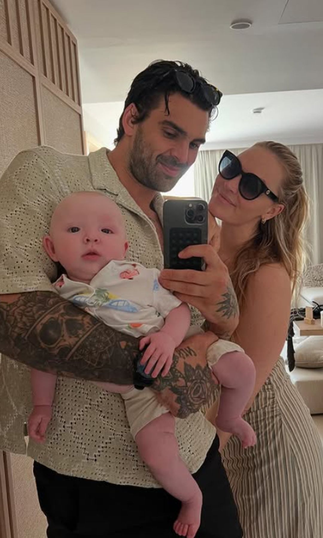 Adam Collard and Laura Woods taking a selfie with a baby
