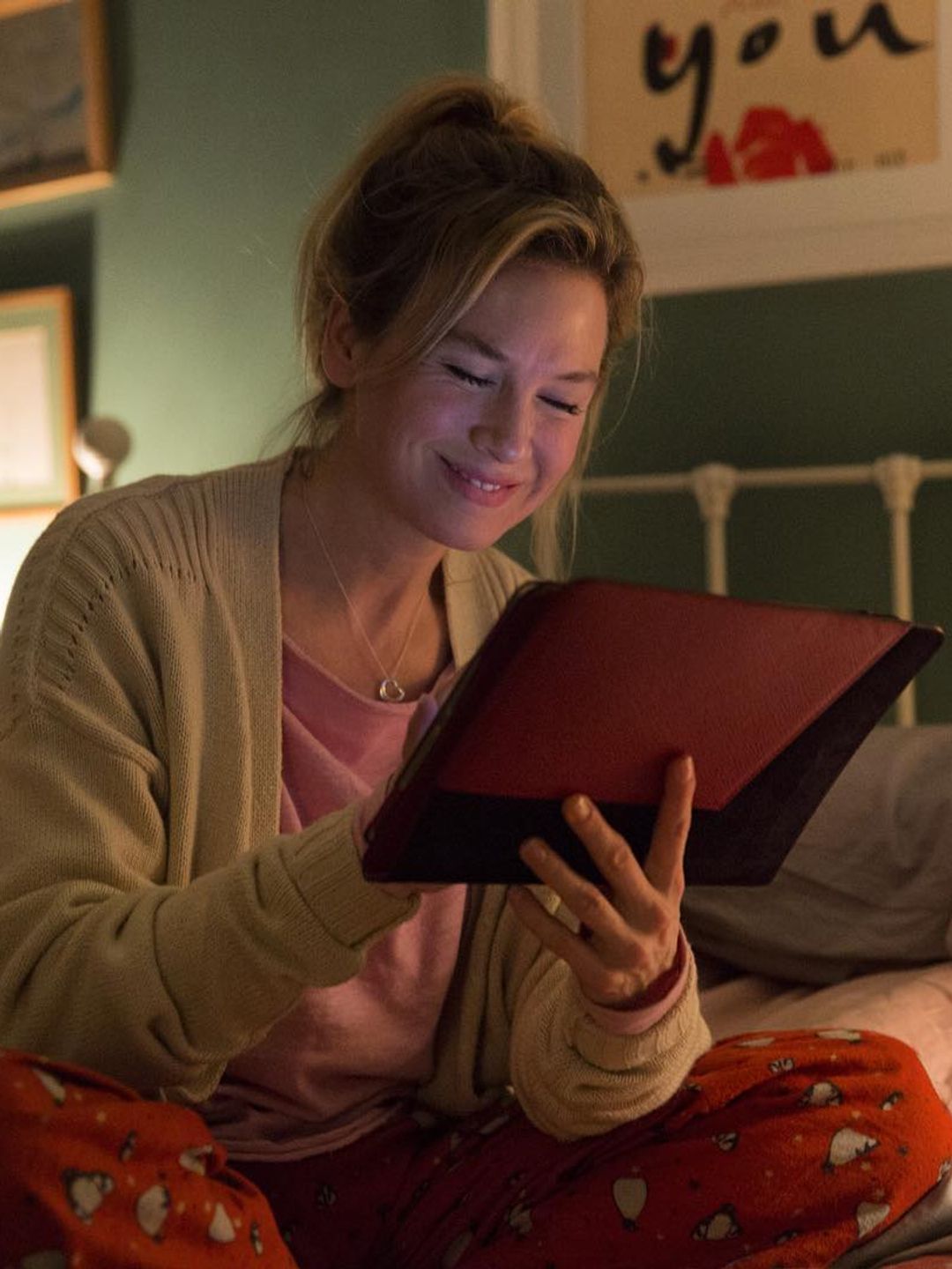 A still from Bridget Jones where actress Renee Zellweger wears pyjamas to sit on her bed