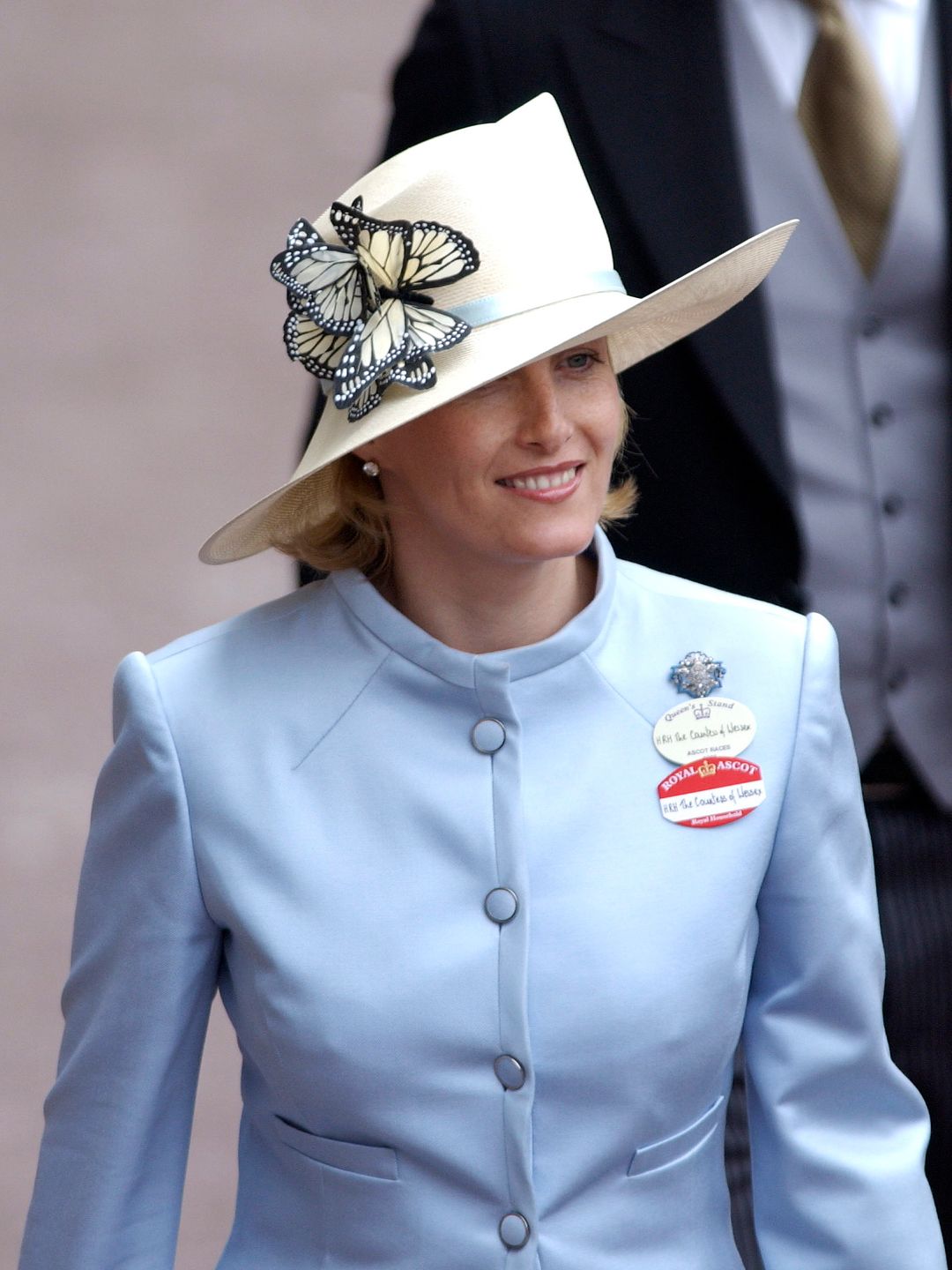 woman wearing blue jacket and butterfly hat 