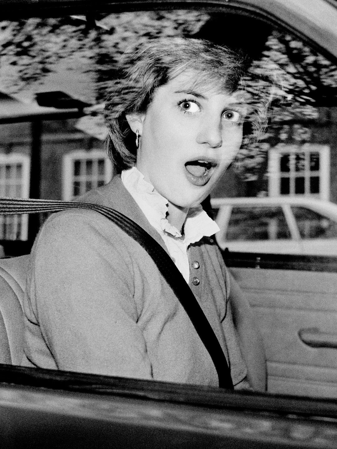 Princess Diana looking surprised in a car