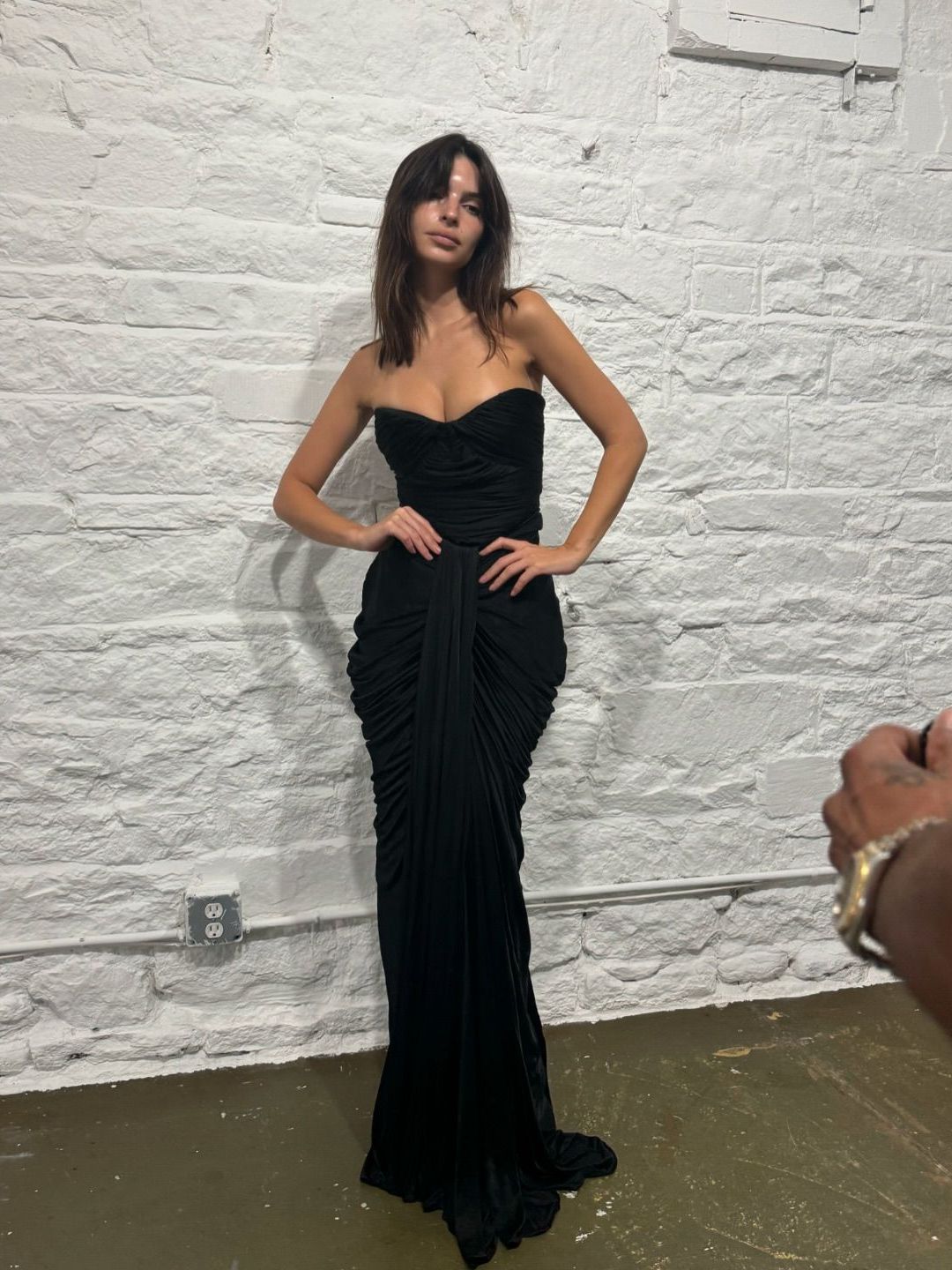 Emily Ratajkowski poses in a black gown during NYFW