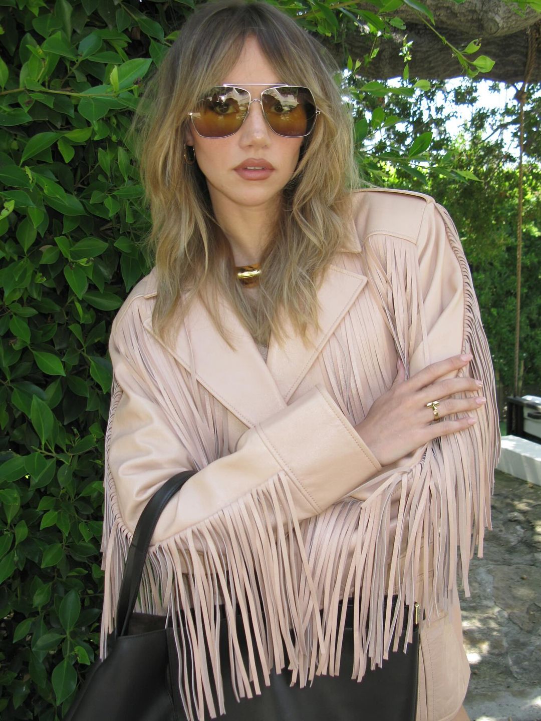 Suki Waterhouse poses in a leather fringe jacket