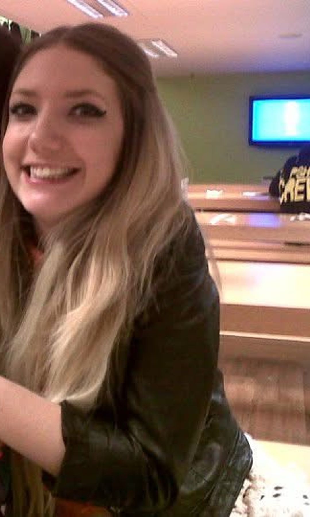 Me, grinning in a black leather jacket in a staff room