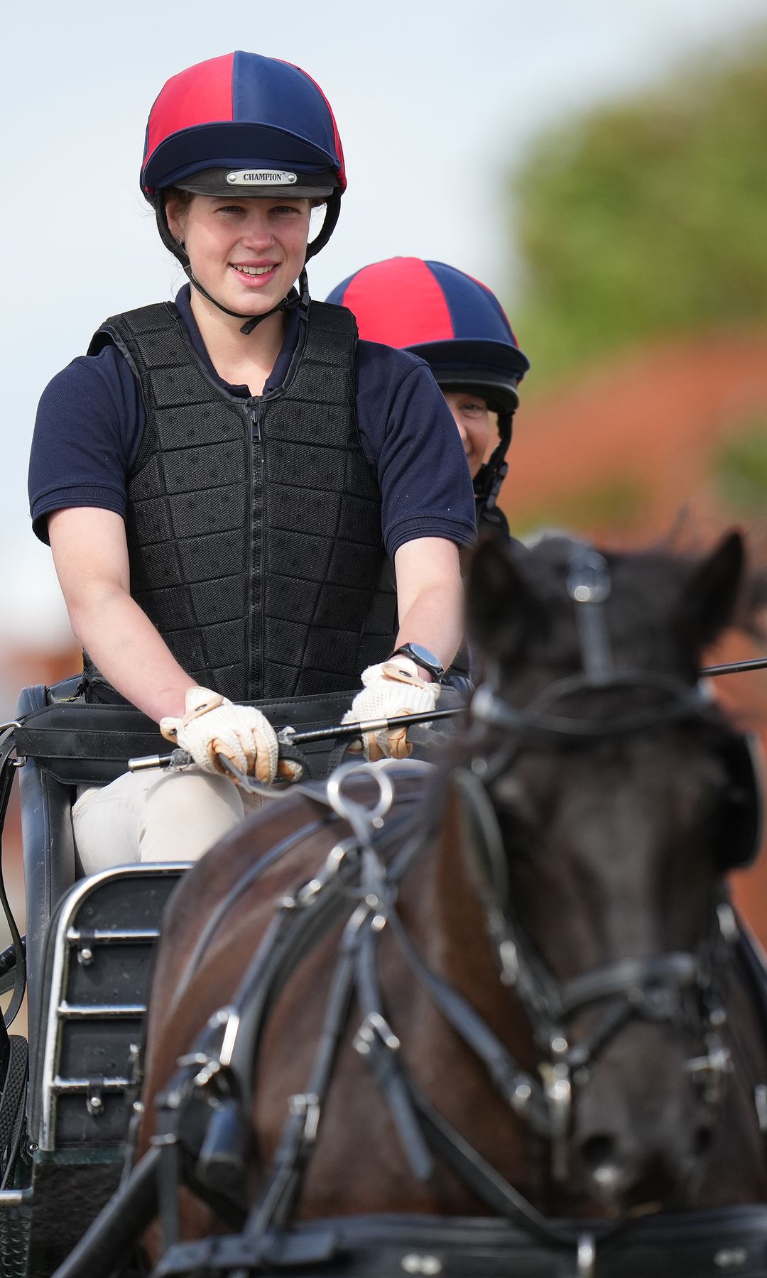 Lady Louise Windsor grinning hwile driving a carriage