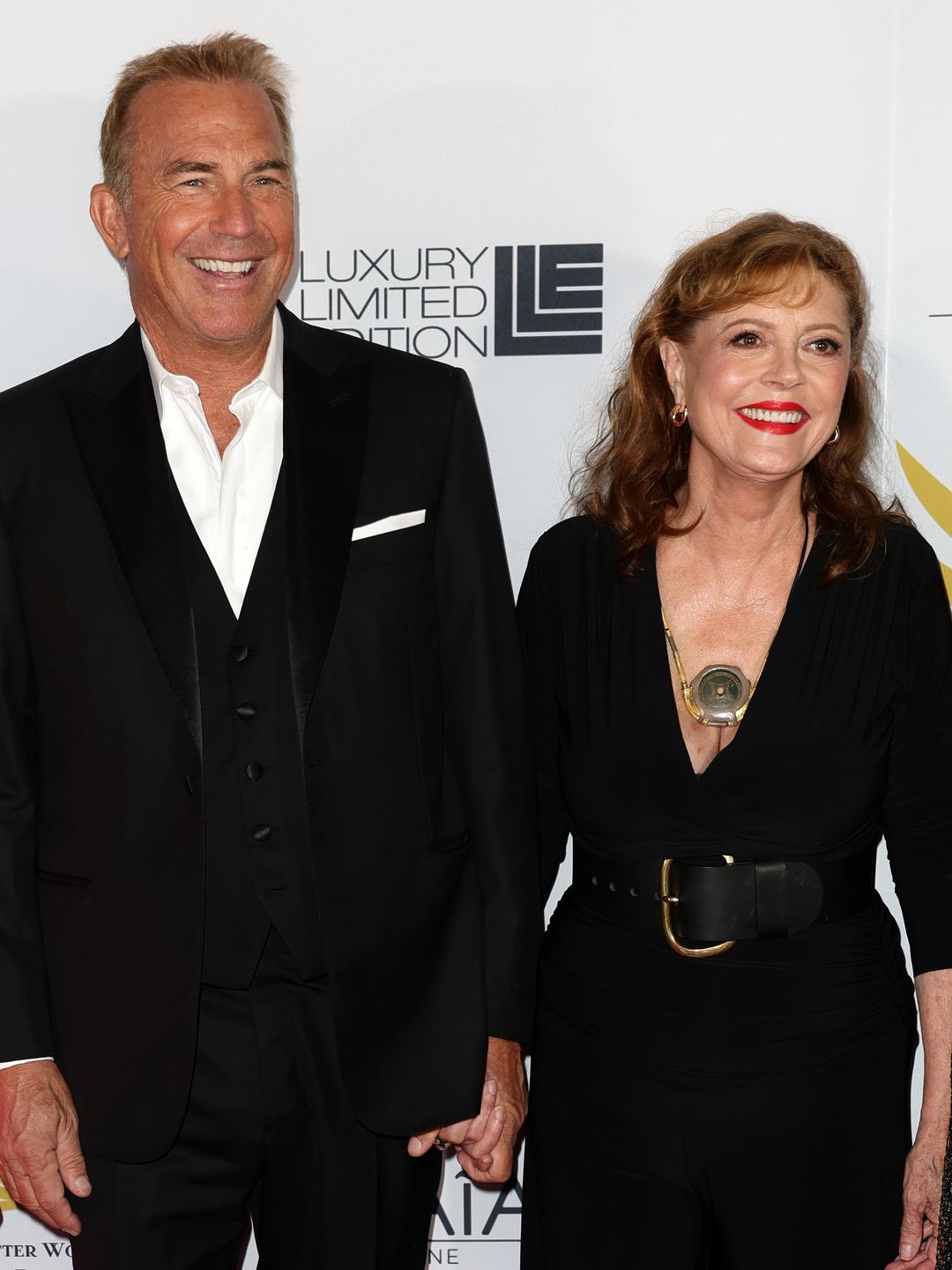 Kevin Costner in a black suit and Susan Sarandon in a black dress