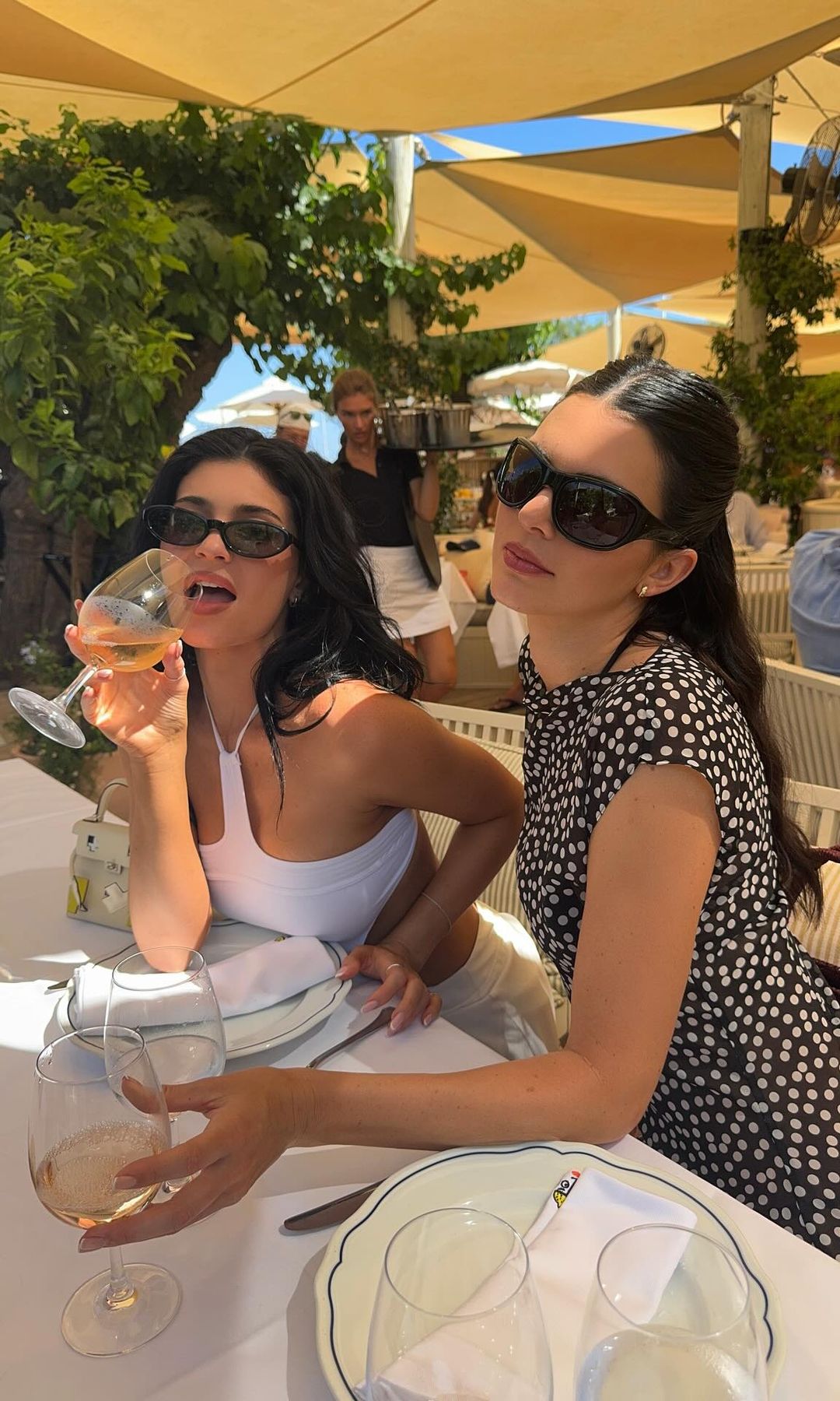 Kylie and Kendall Jenner pose drinking wine while on holiday