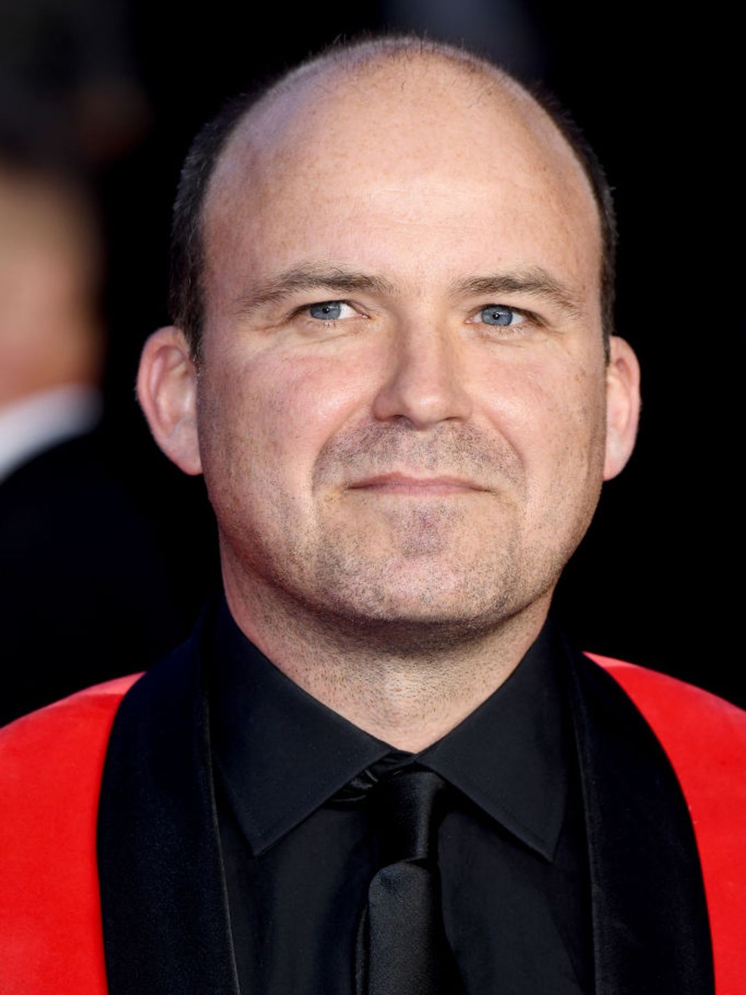 Rory Kinnear wearing a red suit at a premiere