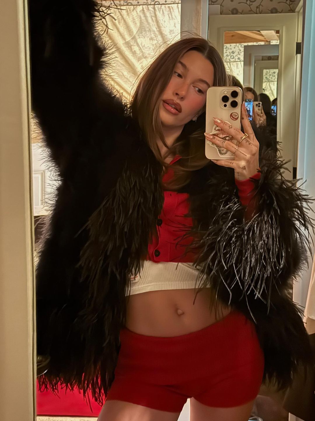 Hailey Bieber poses in a red short and cardigan set on her Instagram