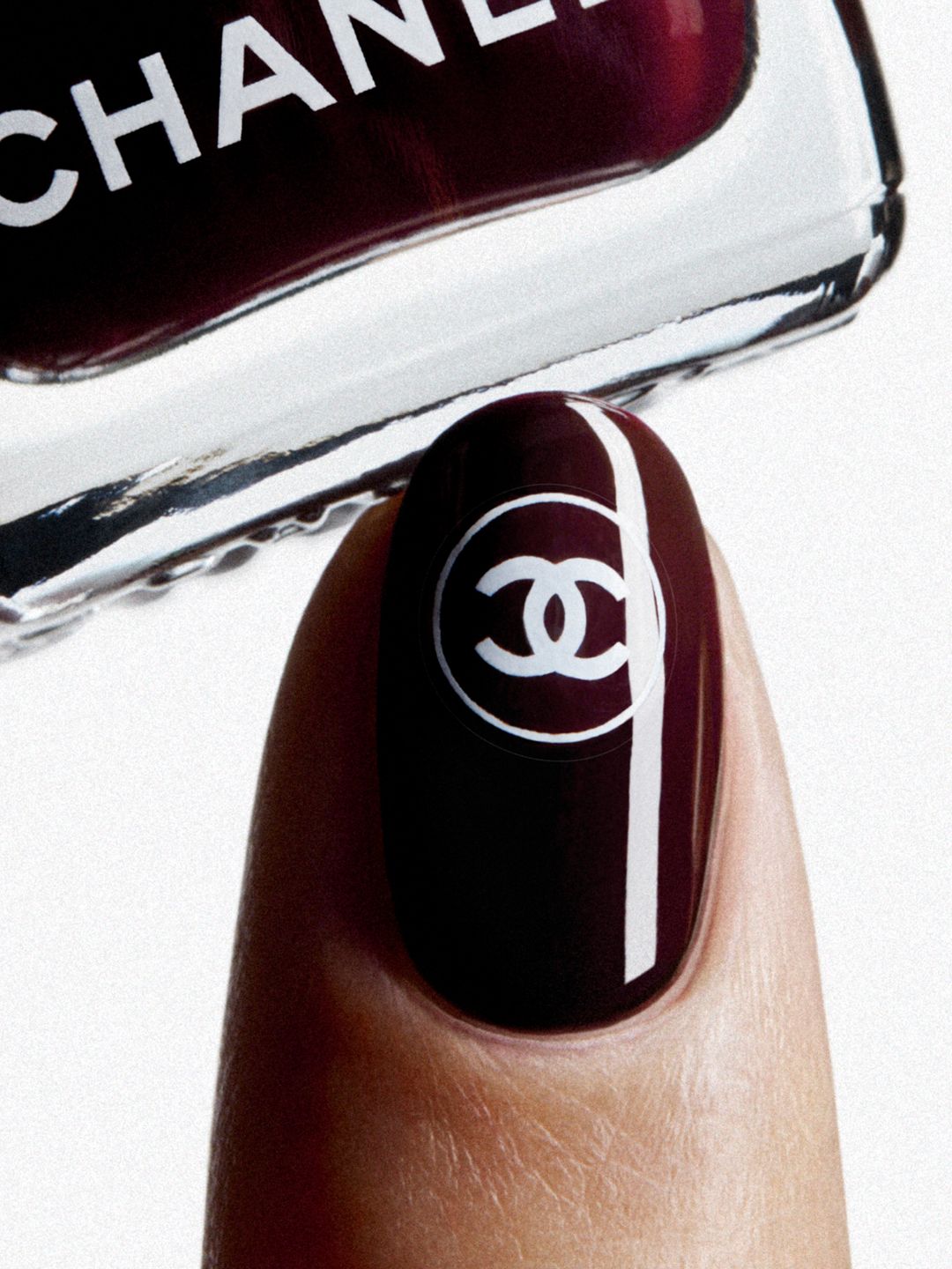 Deep wine-coloured nail polish with white double-C sticker 