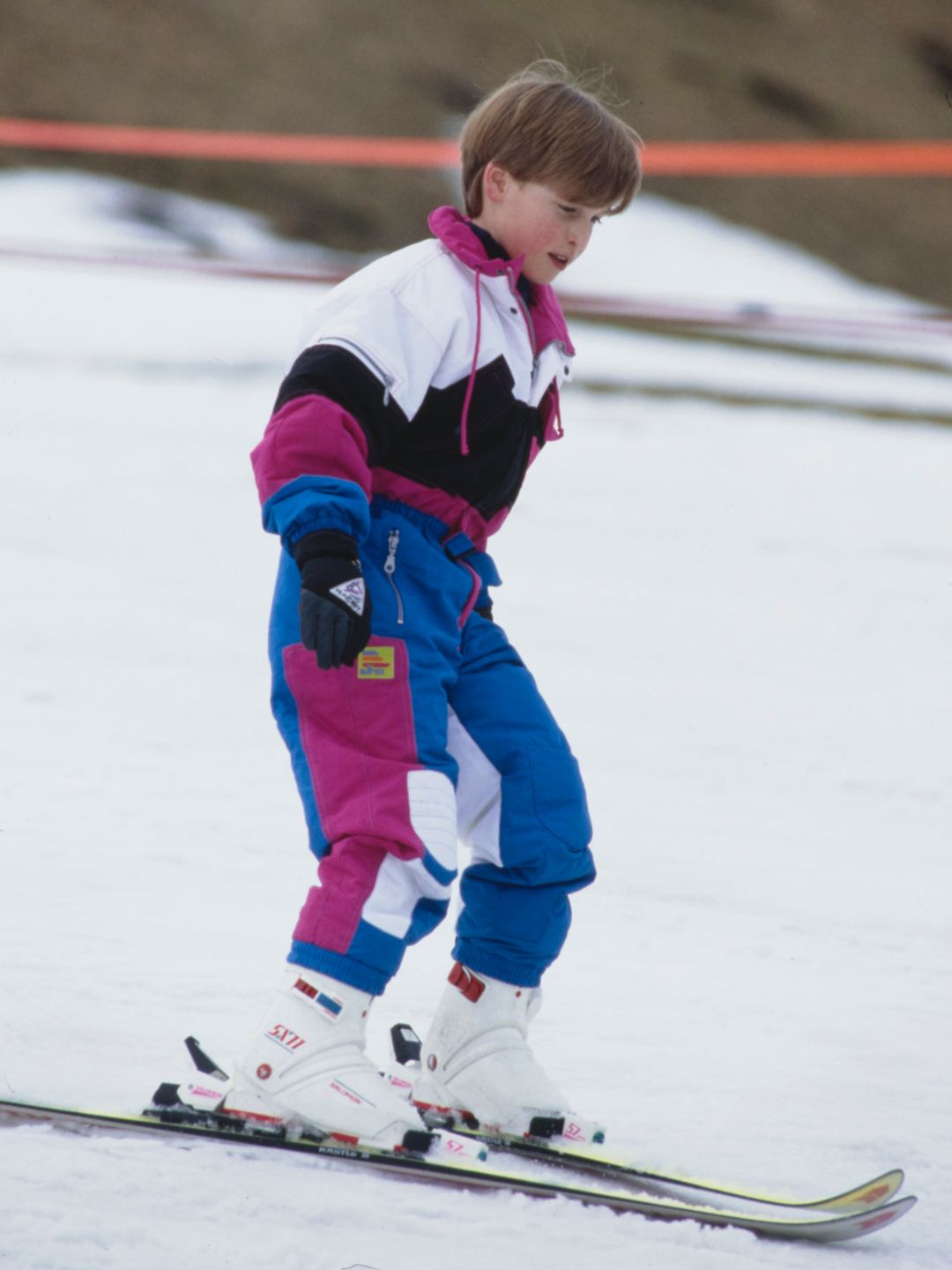 Prince William, wearing a blue, pink, black and white ski suit, during a ski holiday in Lech, Austria in 1991