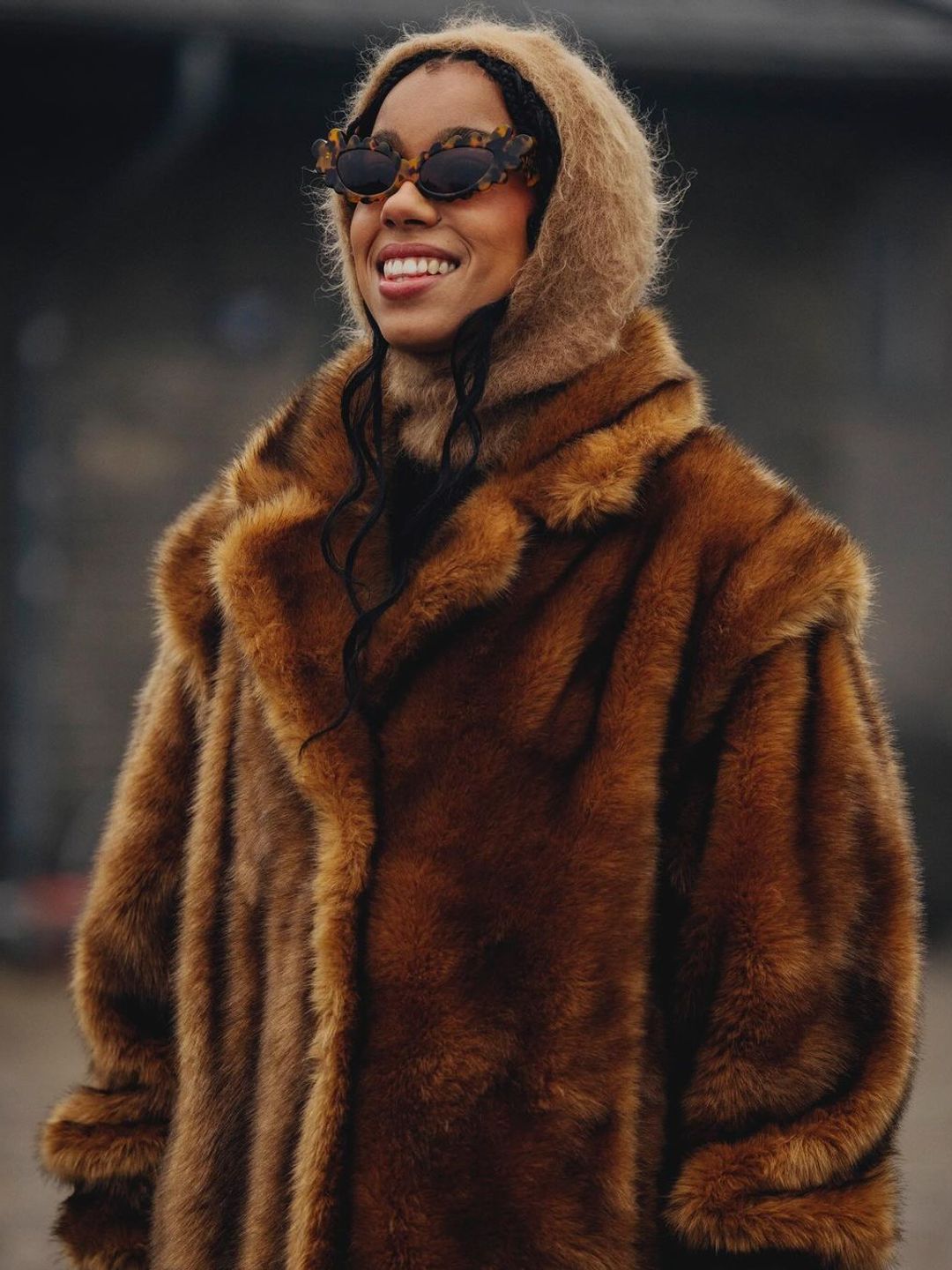 @amaka.hamelijnck wears a fur coat, hood and sunglasses while in Copenhagen for fashion week