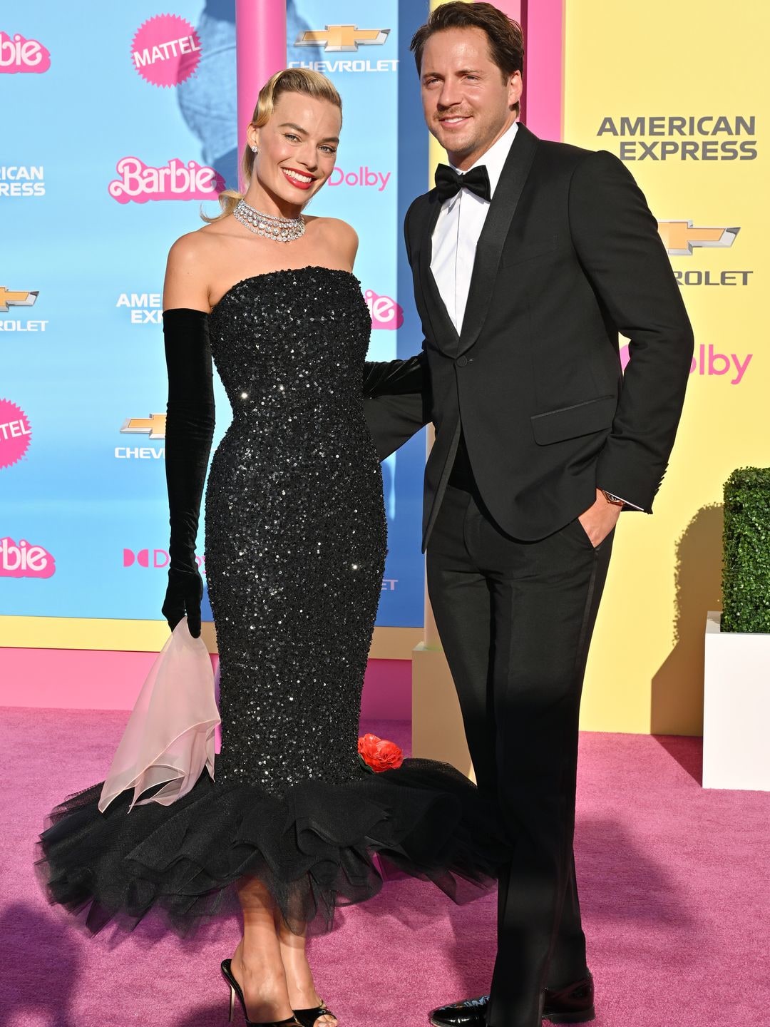 Margot Robbie and Tom Ackerley smiling on the Barbie pink carpet