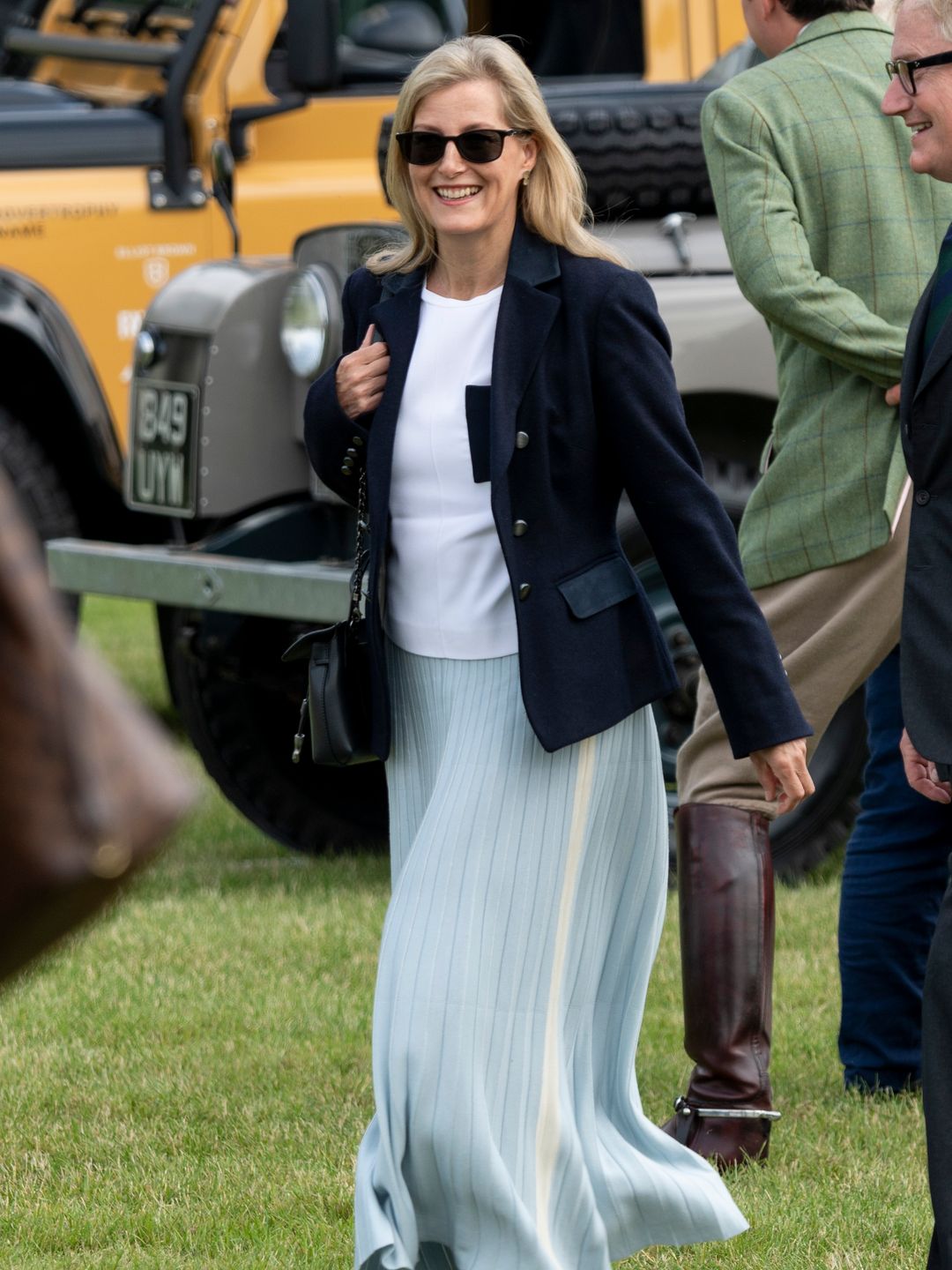 duchess sophie in blue pleated skirt and trainers