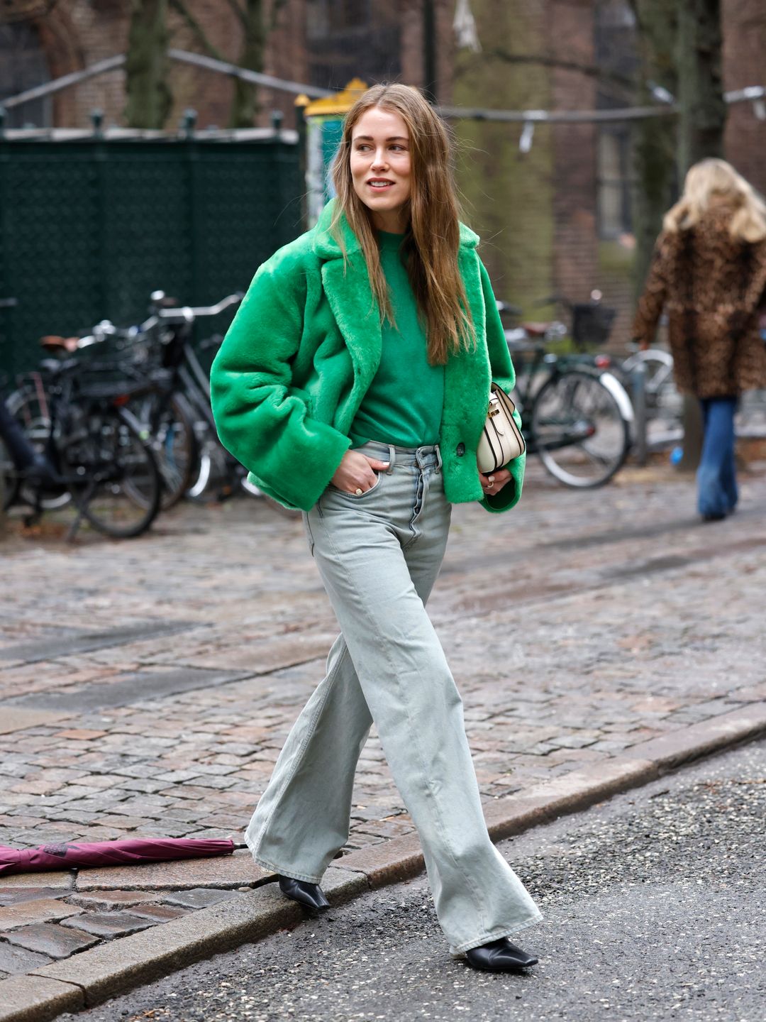 Annabel Rosendahl wearing a green faux fur teddy jacket by Onar paired with a green sweater by Loulou Studios and grey flared jean by Acne