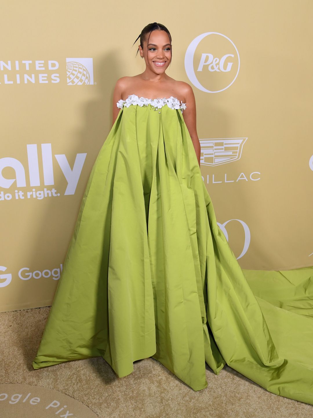 Bianca smiling in a long green dress on a red carpet