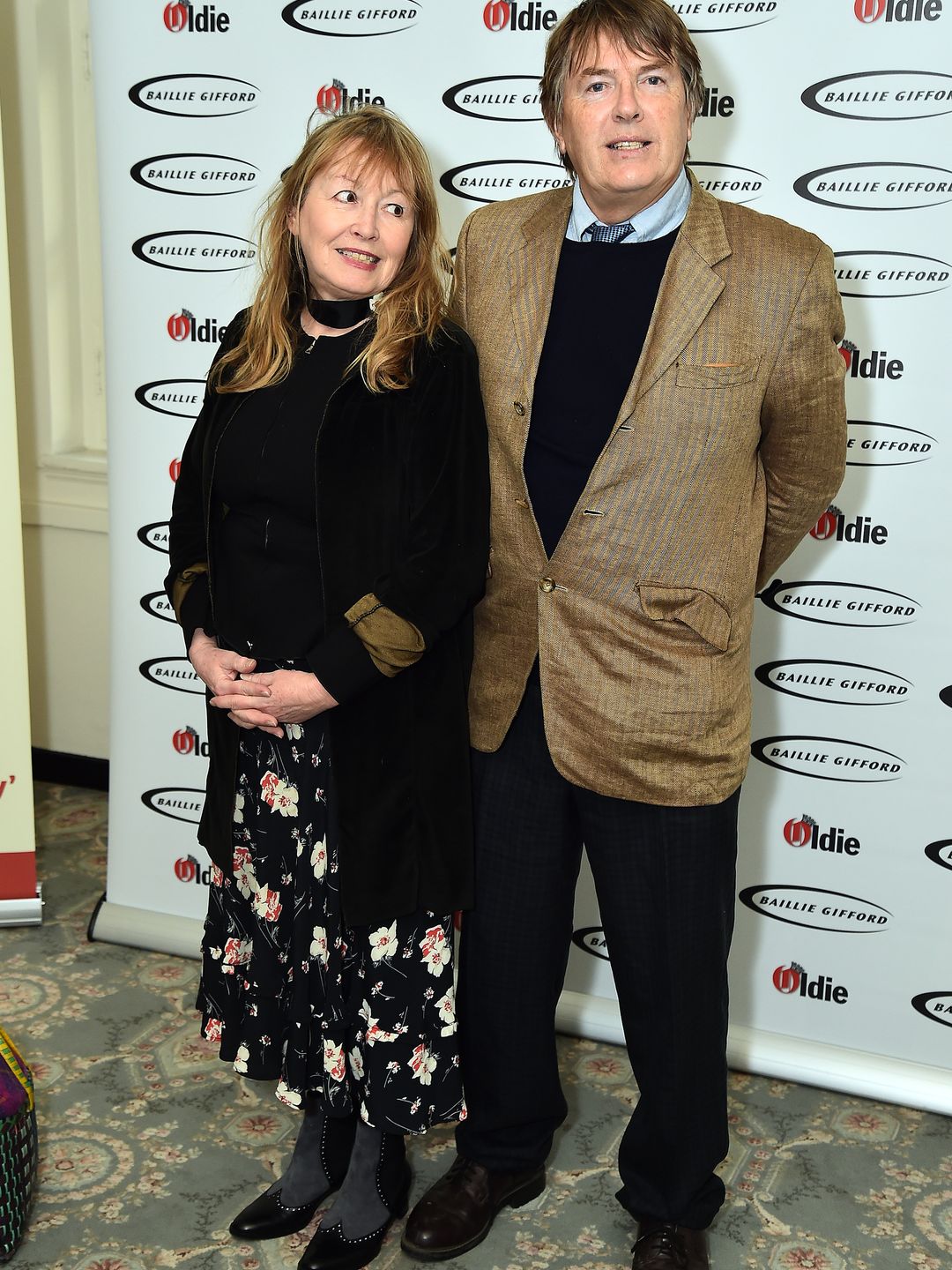 Giles Wood in a brown suit jacket and Mary Killen in a floral dress
