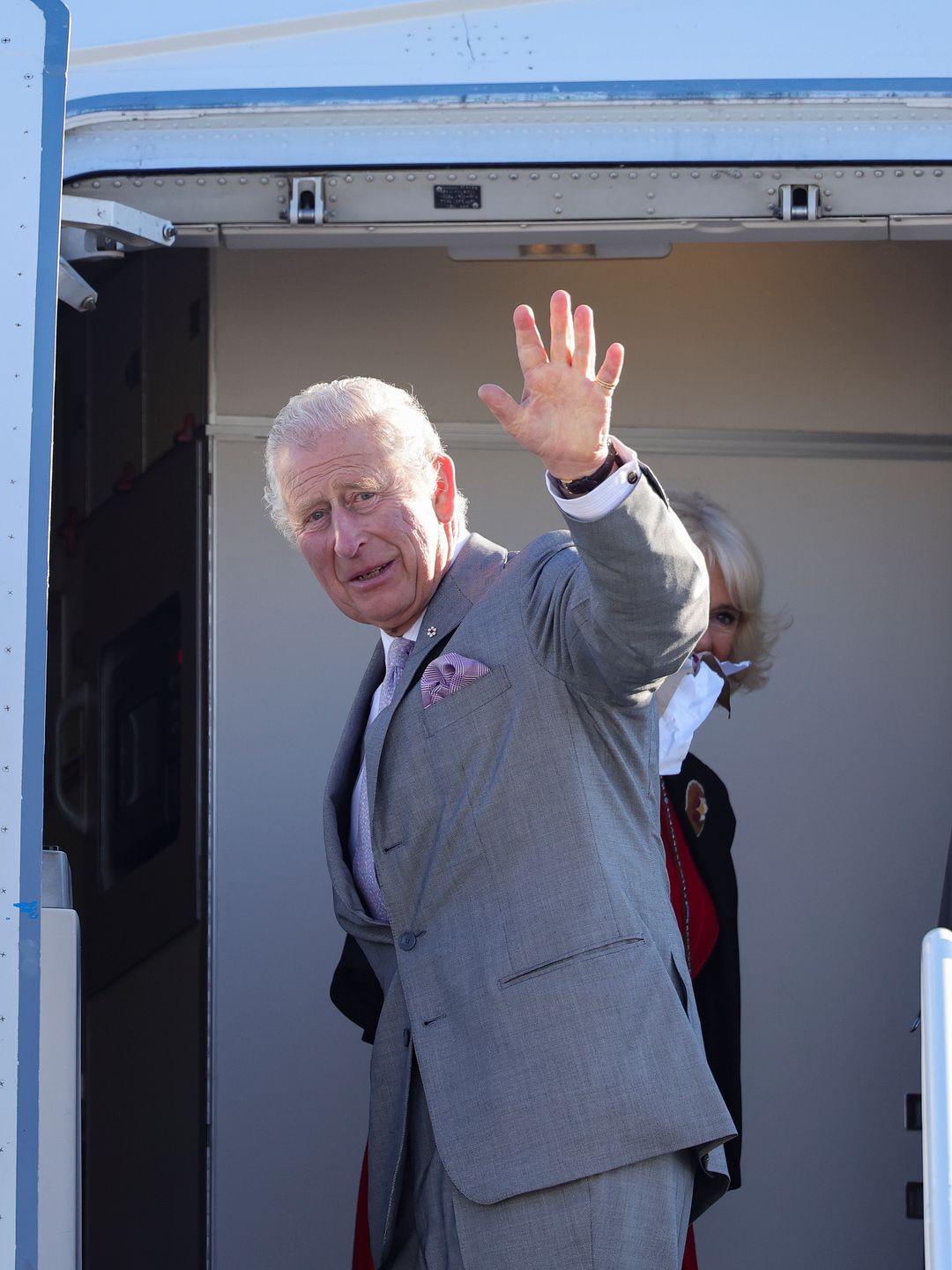 King Charles waving as he gets on a plane