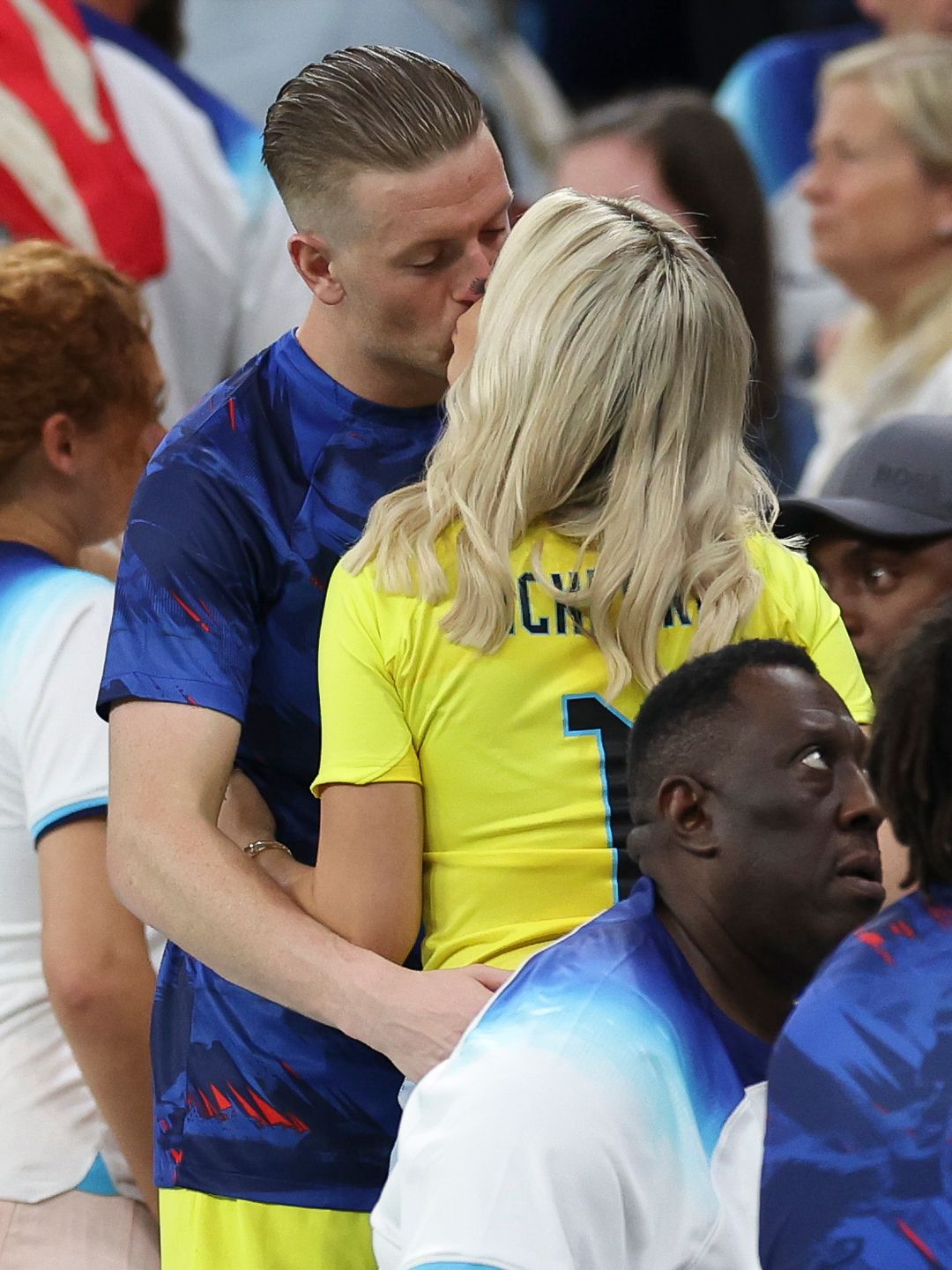 couple kissing at football stadium