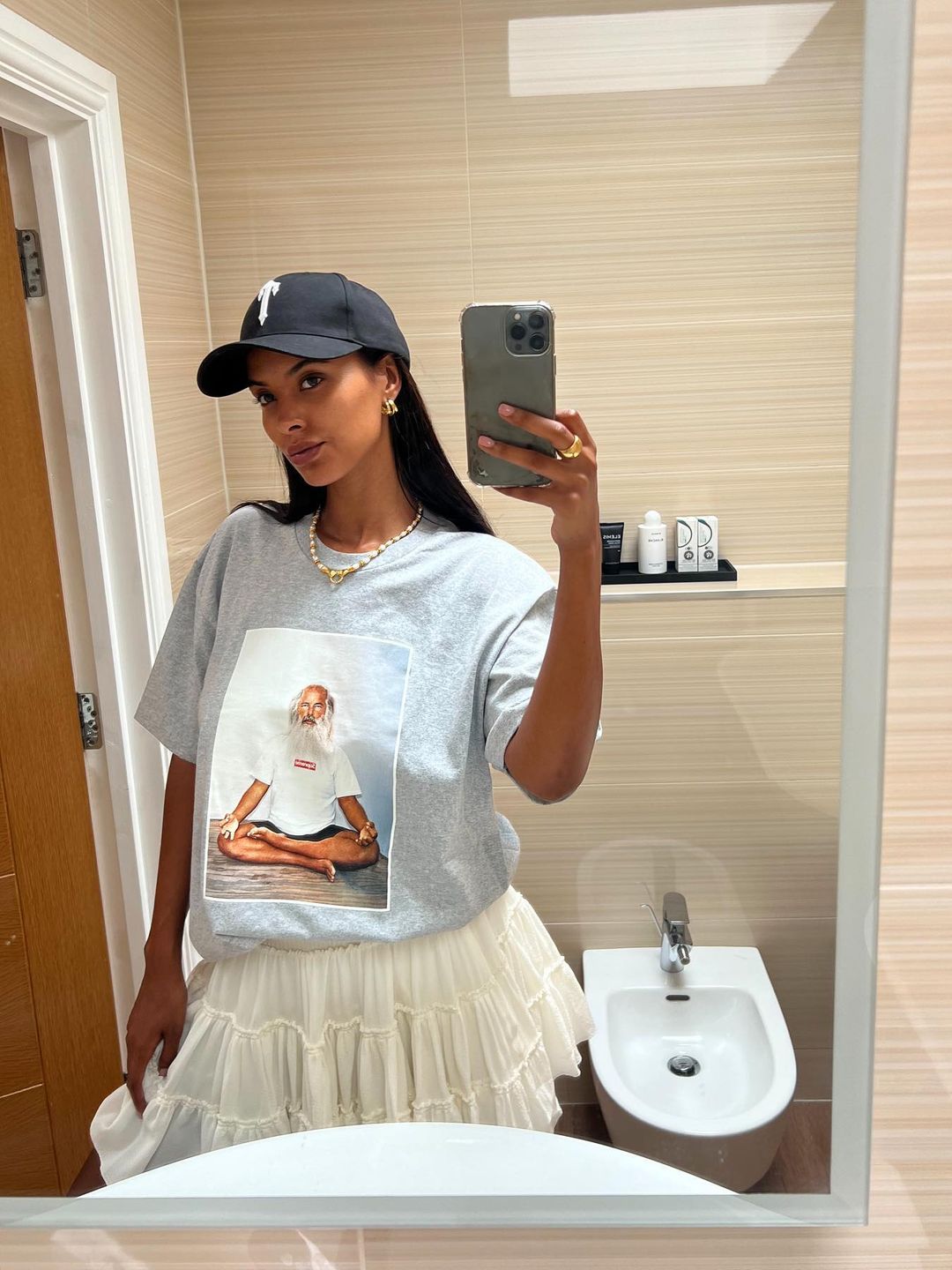 Maya Jama takes a mirror selfie in a mini skirt and graphic tee