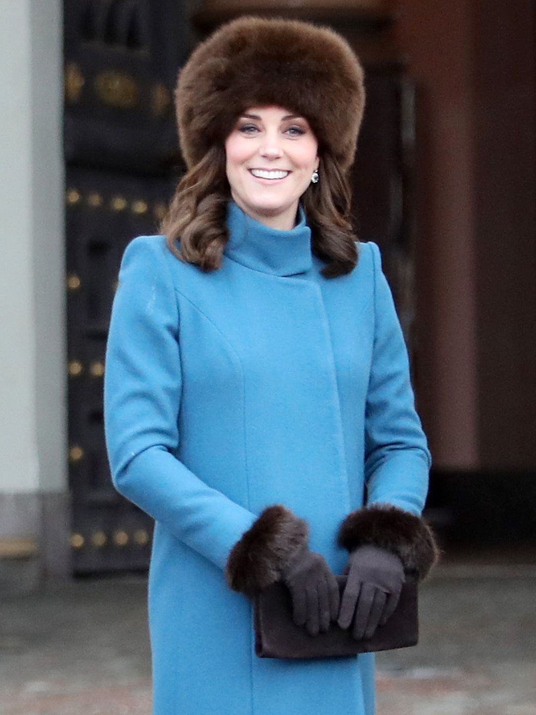 Kate Middleton wearing a blue coat and a brown fluffy hat 