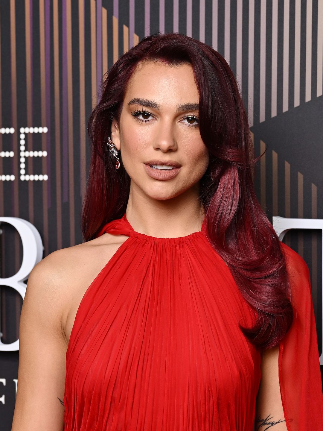 Dua Lipa wearing a red gown at the BAFTAs 