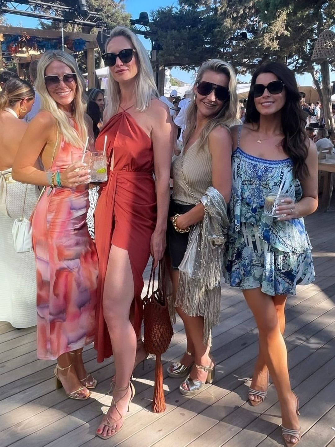 Helen Skelton in black shorts and a gold top and heels with friends