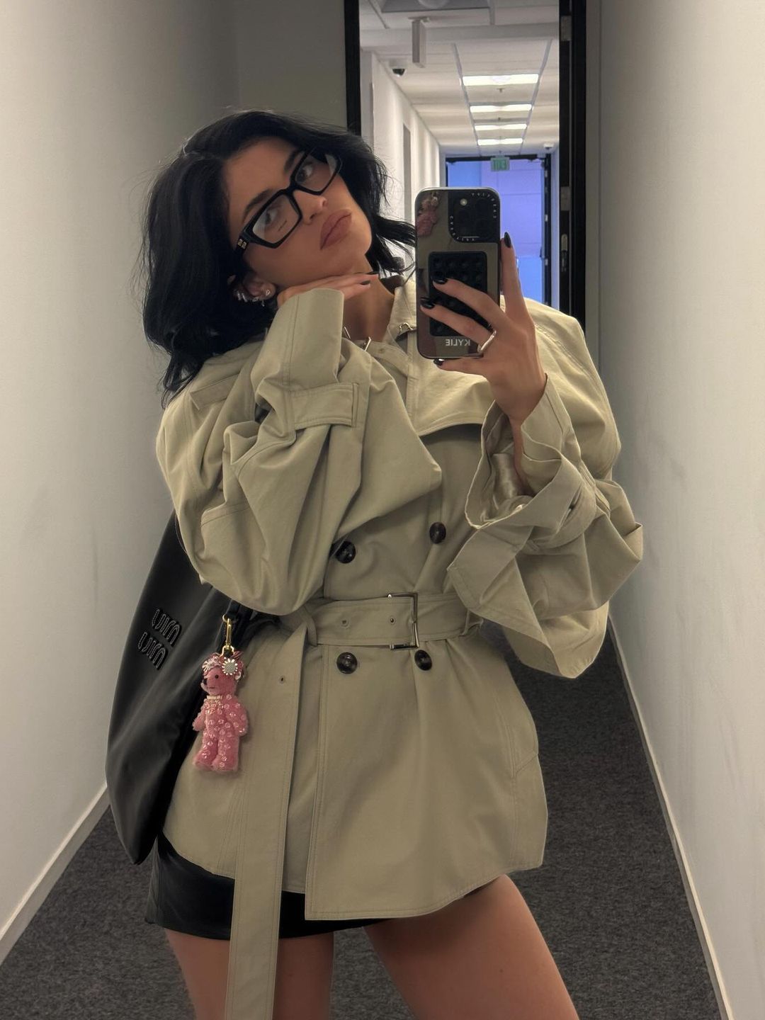 Kylie Jenner poses in a cropped trench and leather mini skirt on her Instagram