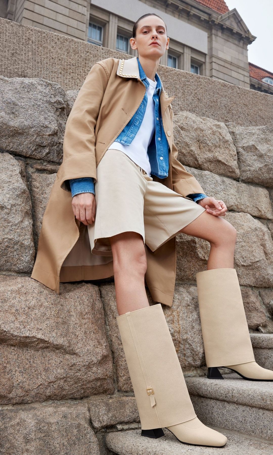 A model poses in a pair of suede boots and tan shorts 