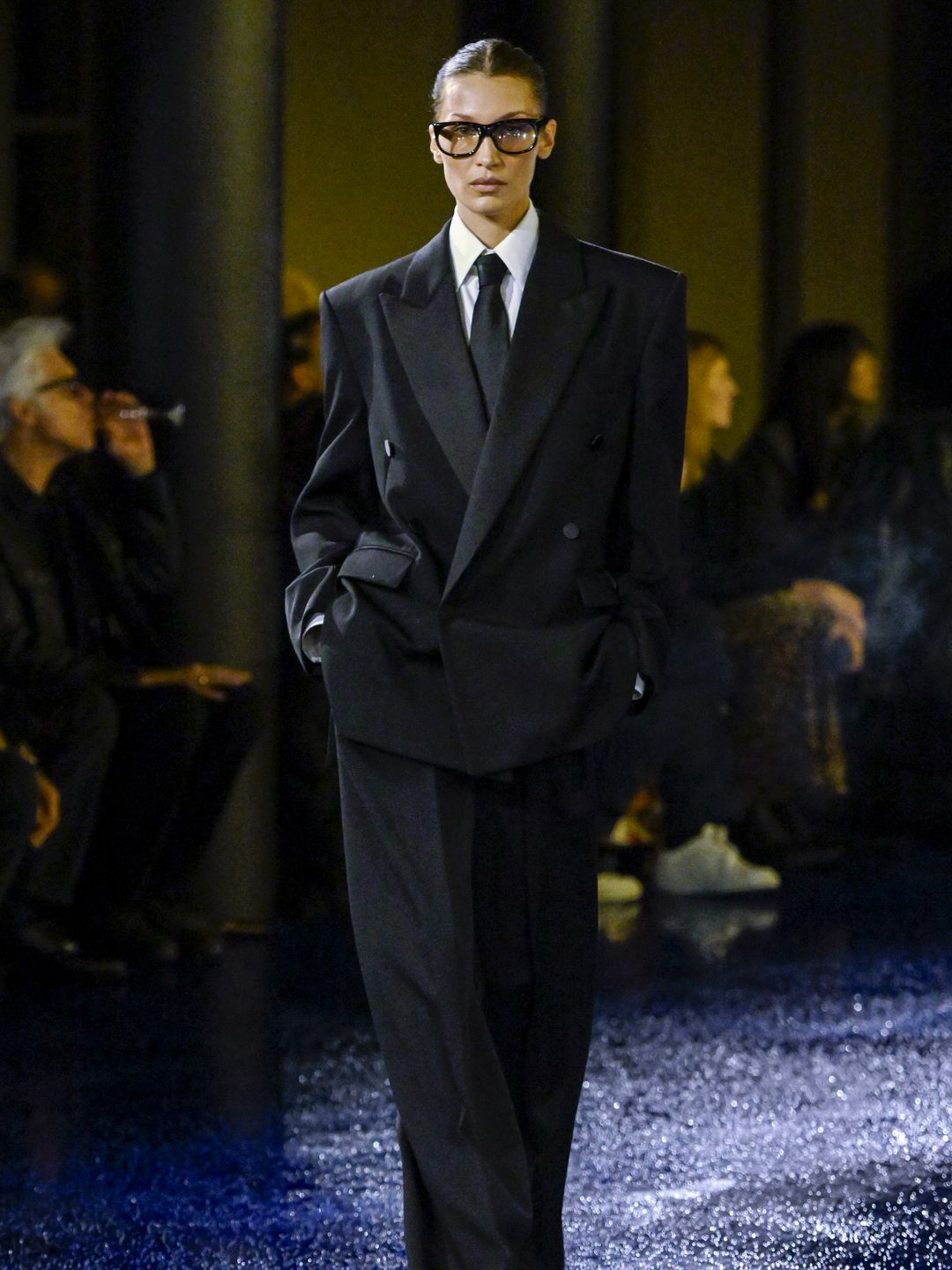 Bella Hadid walks the runway during the Saint Laurent Ready to Wear Spring/Summer 2025 fashion show as part of the Paris Fashion Week in a black oversized suit look