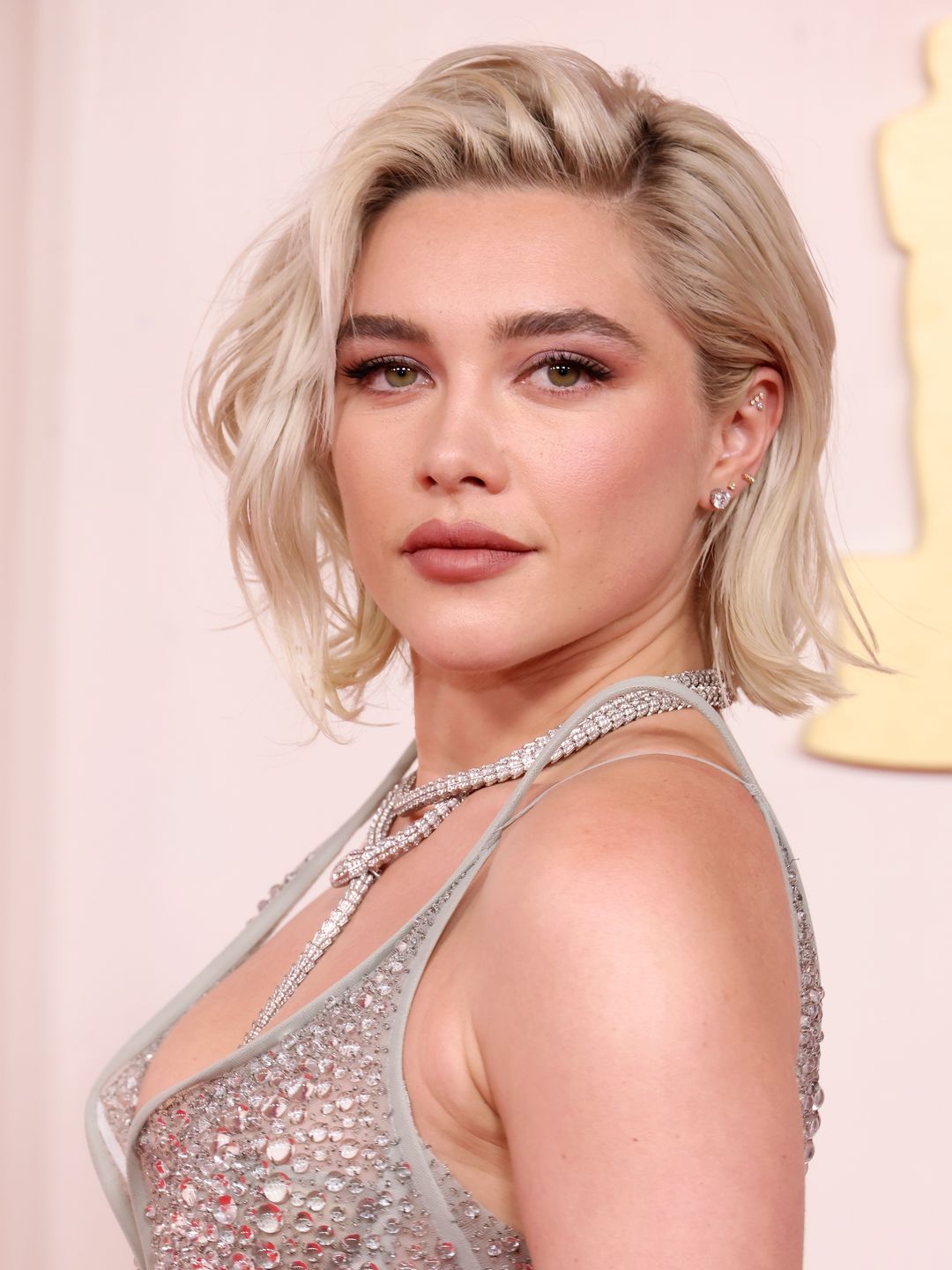 Florence Pugh smiling in a silver gown at the Oscars 