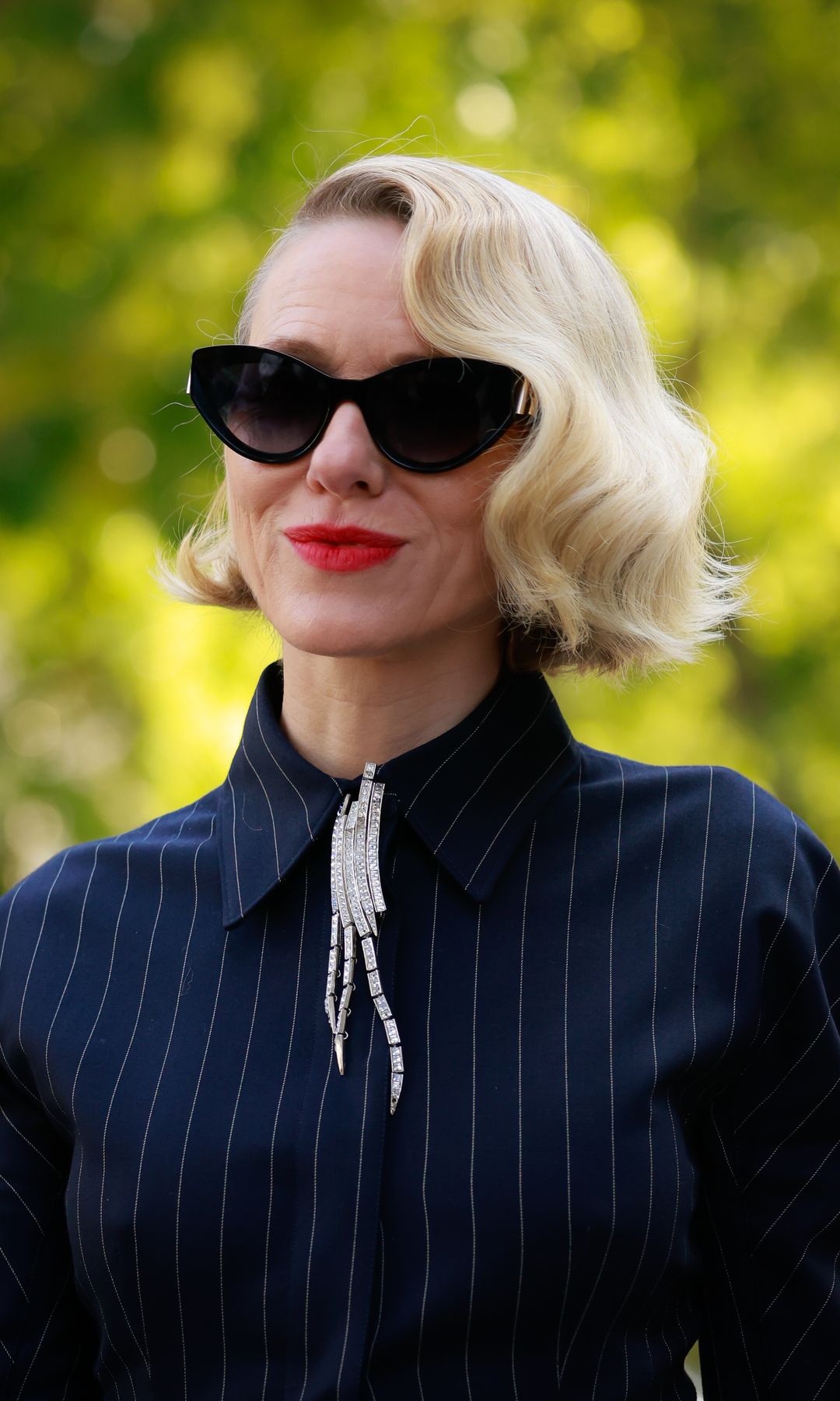 naomi watts wearing striped shirt and diamond brooch jewellery