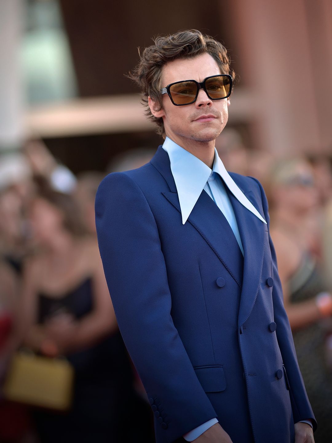 Harry Styles wears a navy blue suit and oversized collared shirt and sunglasses to the Venice International Film Festival 2022.