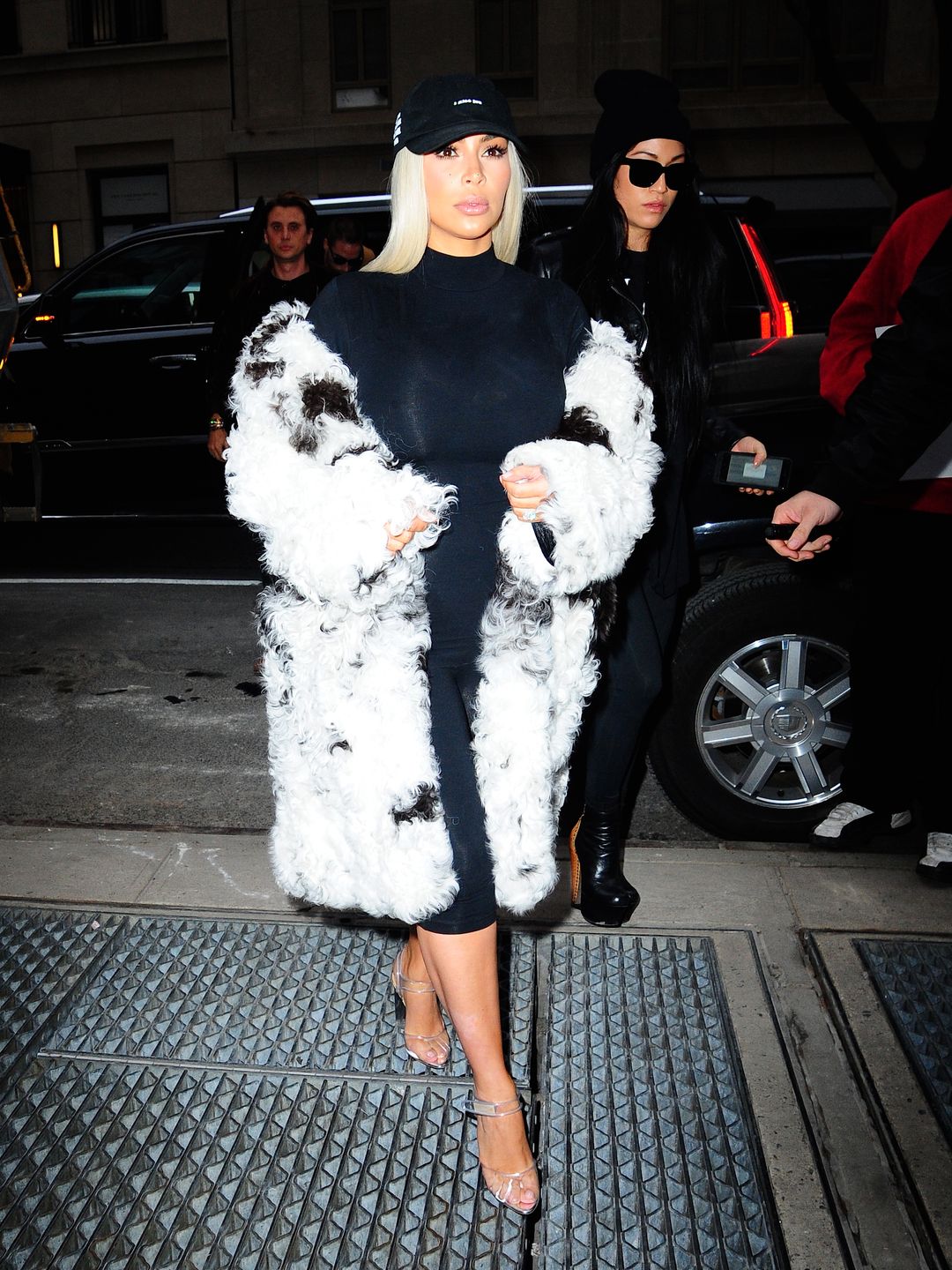 Kim Kardashian wearing a white textured coat with a black baseball cap in 2016
