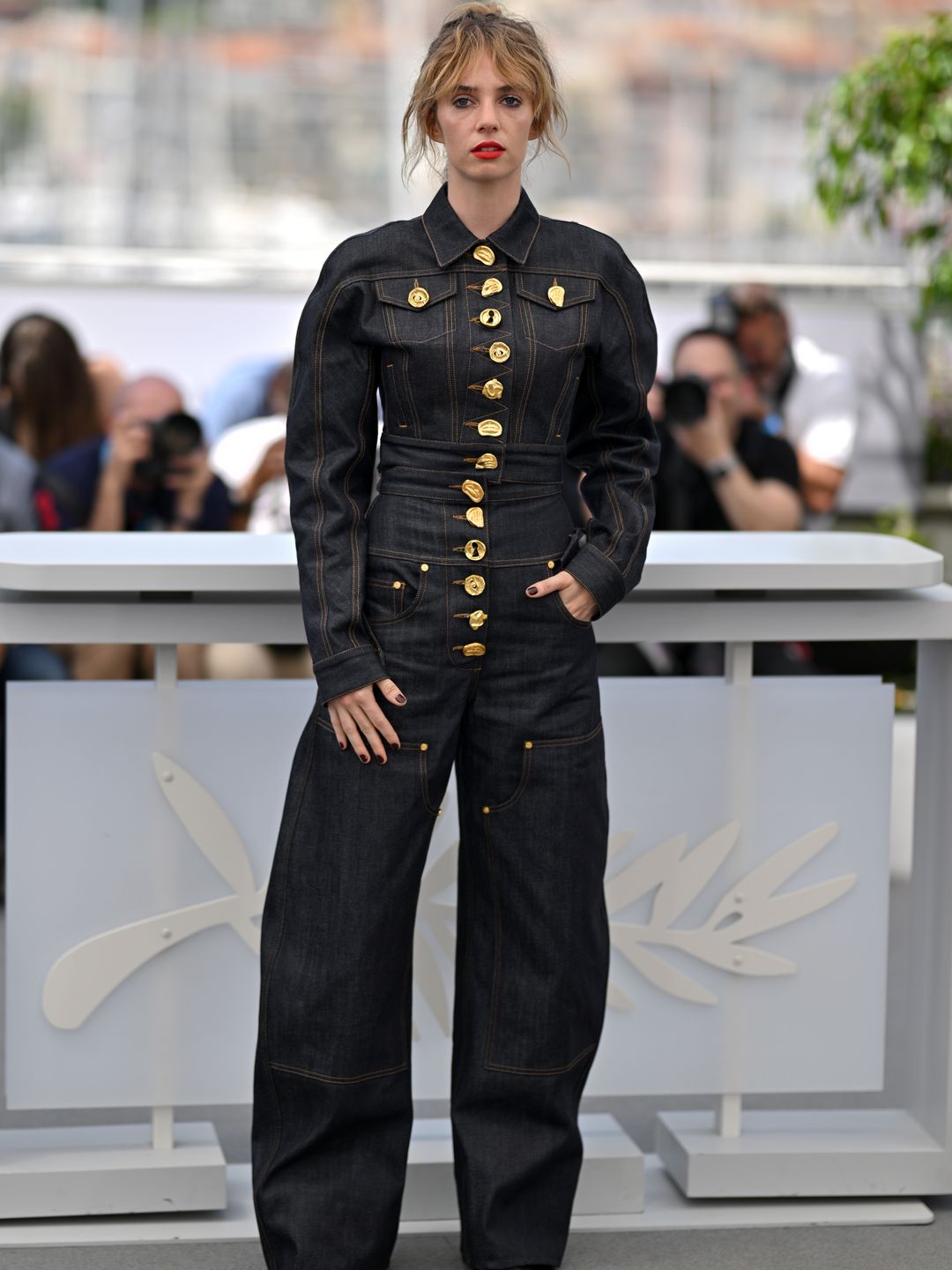 Maya Hawke looked cool in a dark denim jumpsuit with gold button adornments 