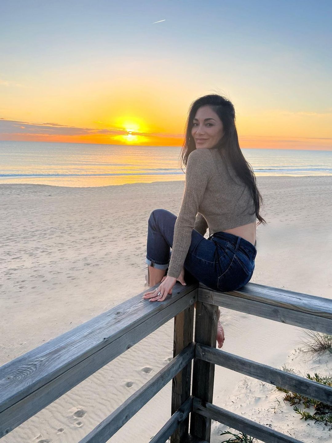 Nicole Scherzinger na praia com pôr do sol 