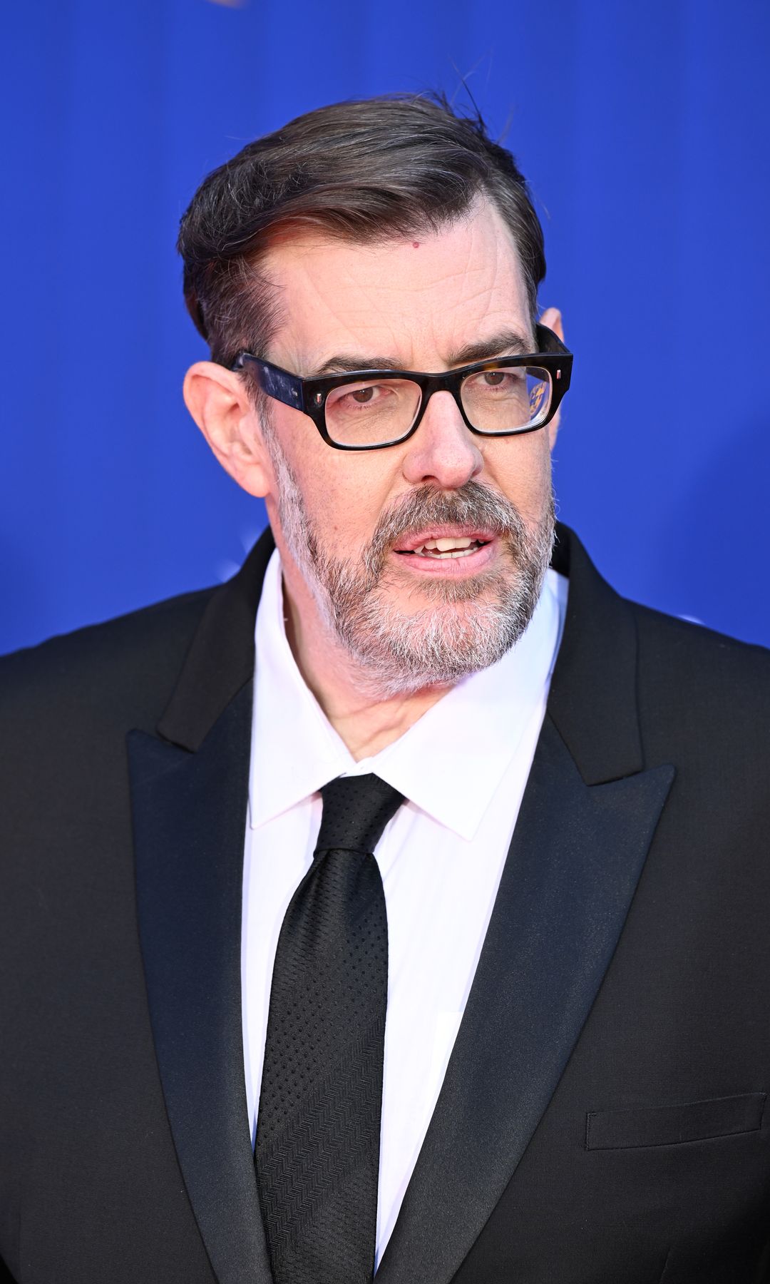 Richard Osman in a black suit