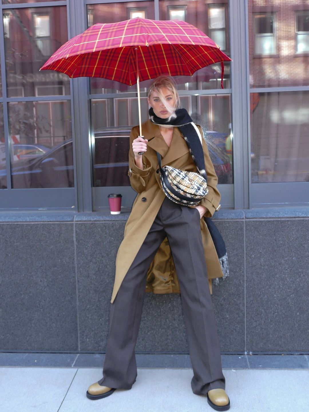 Elsa Hosk poses for a photo in a trench coat, trouser, biker boots and scarf combo