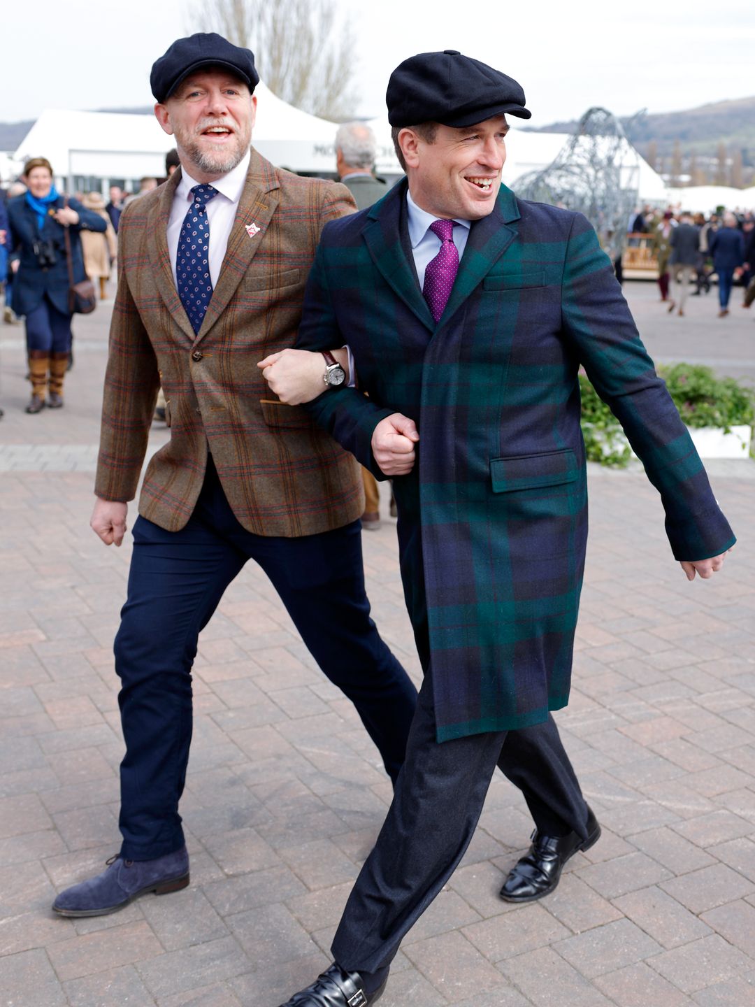 Mike Tindall and Peter Phillips wearing checked suits and flat caps for Cheltenham Festival
