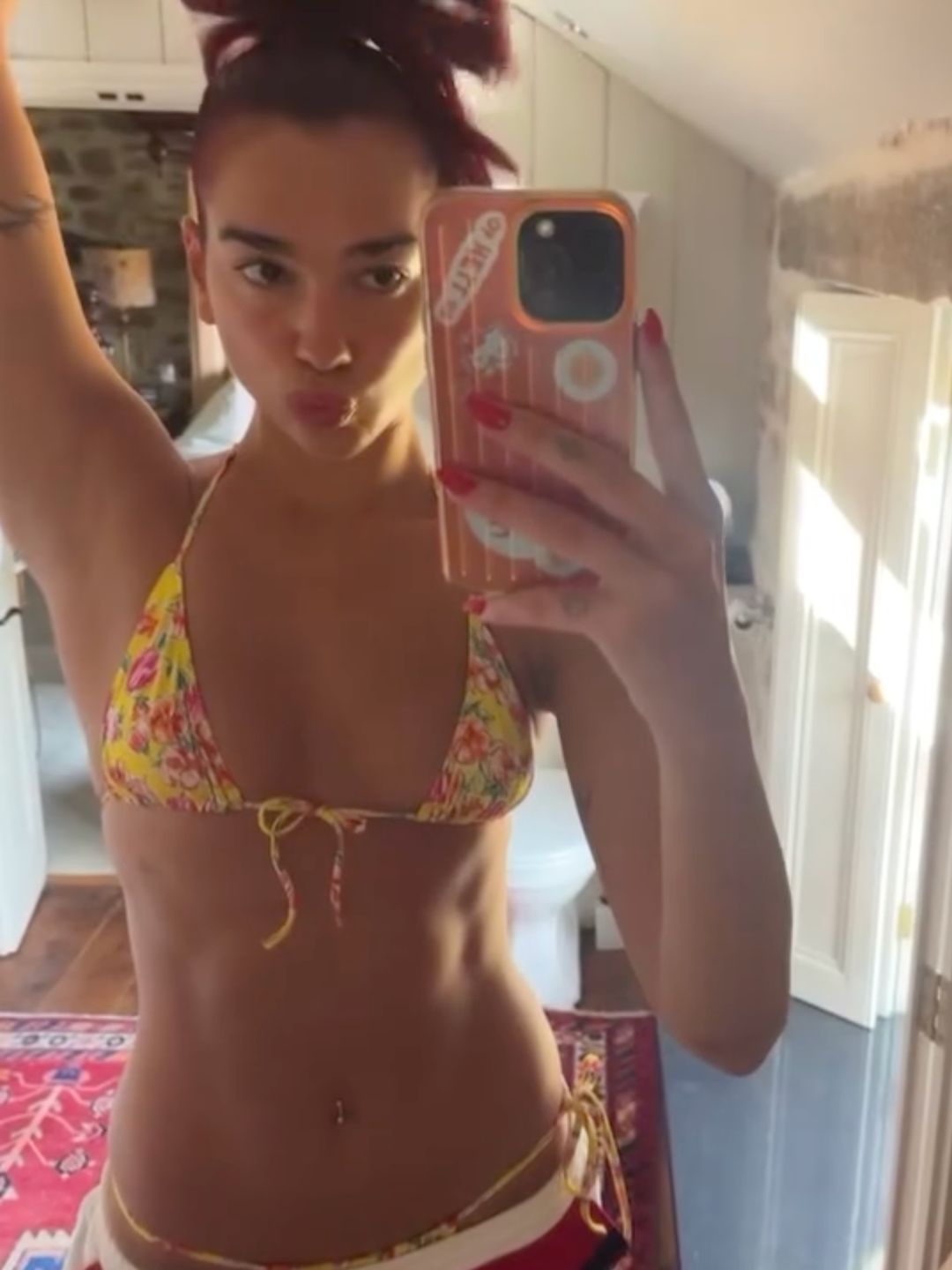 Dua Lipa poses in a yellow bikini