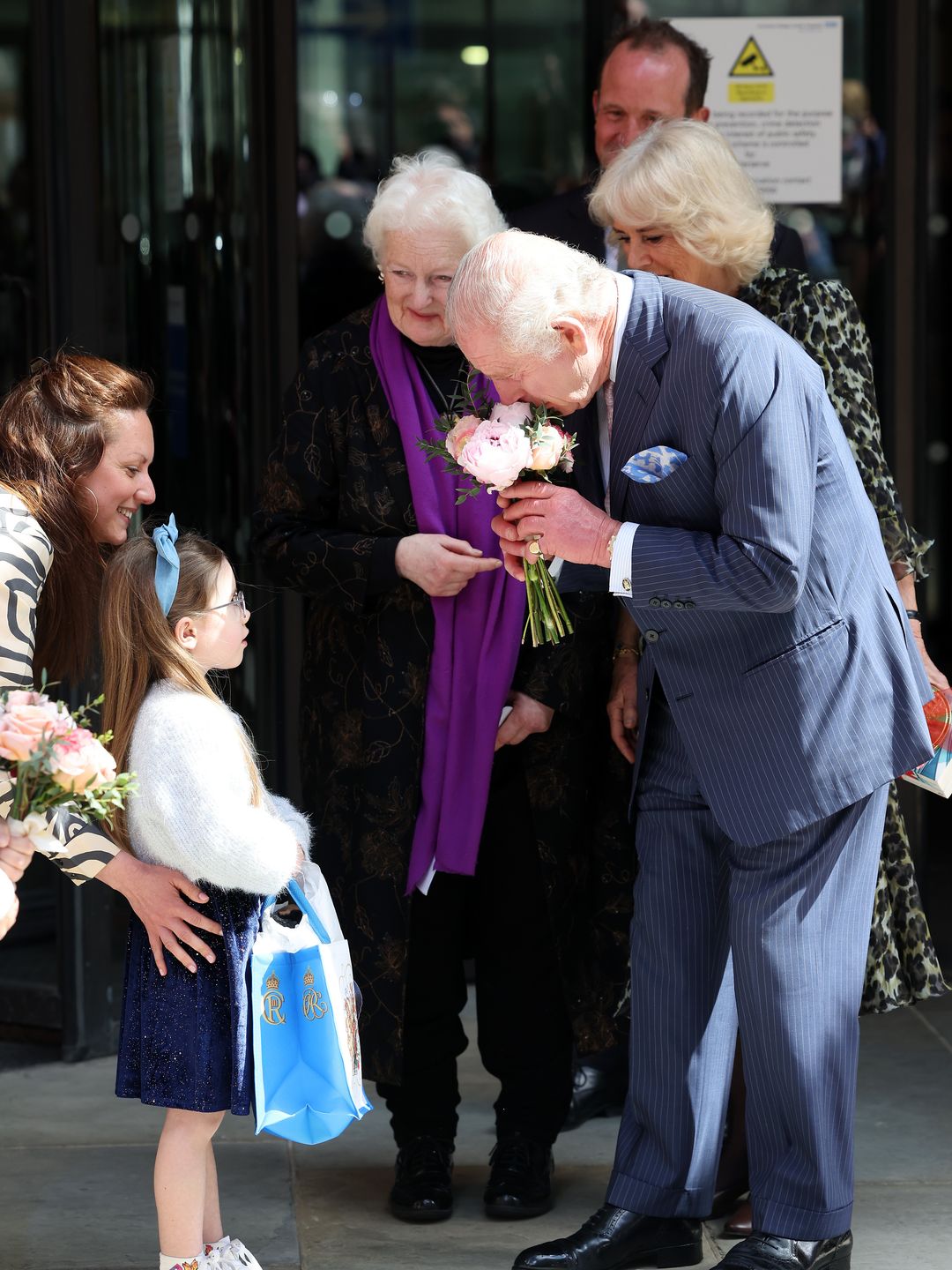 King Charles receiving a bunch of flowers from a young girl