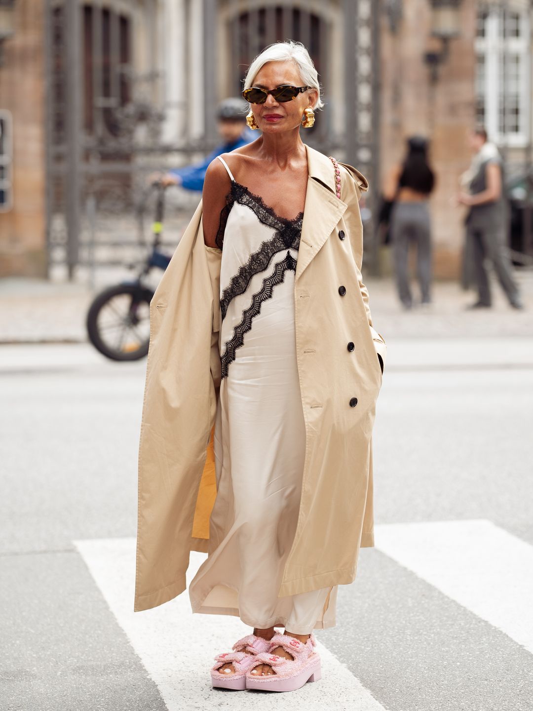 Grece Ghanem wears fantastic pink sandals, a white and black lace slip dress and a classic trench coat.