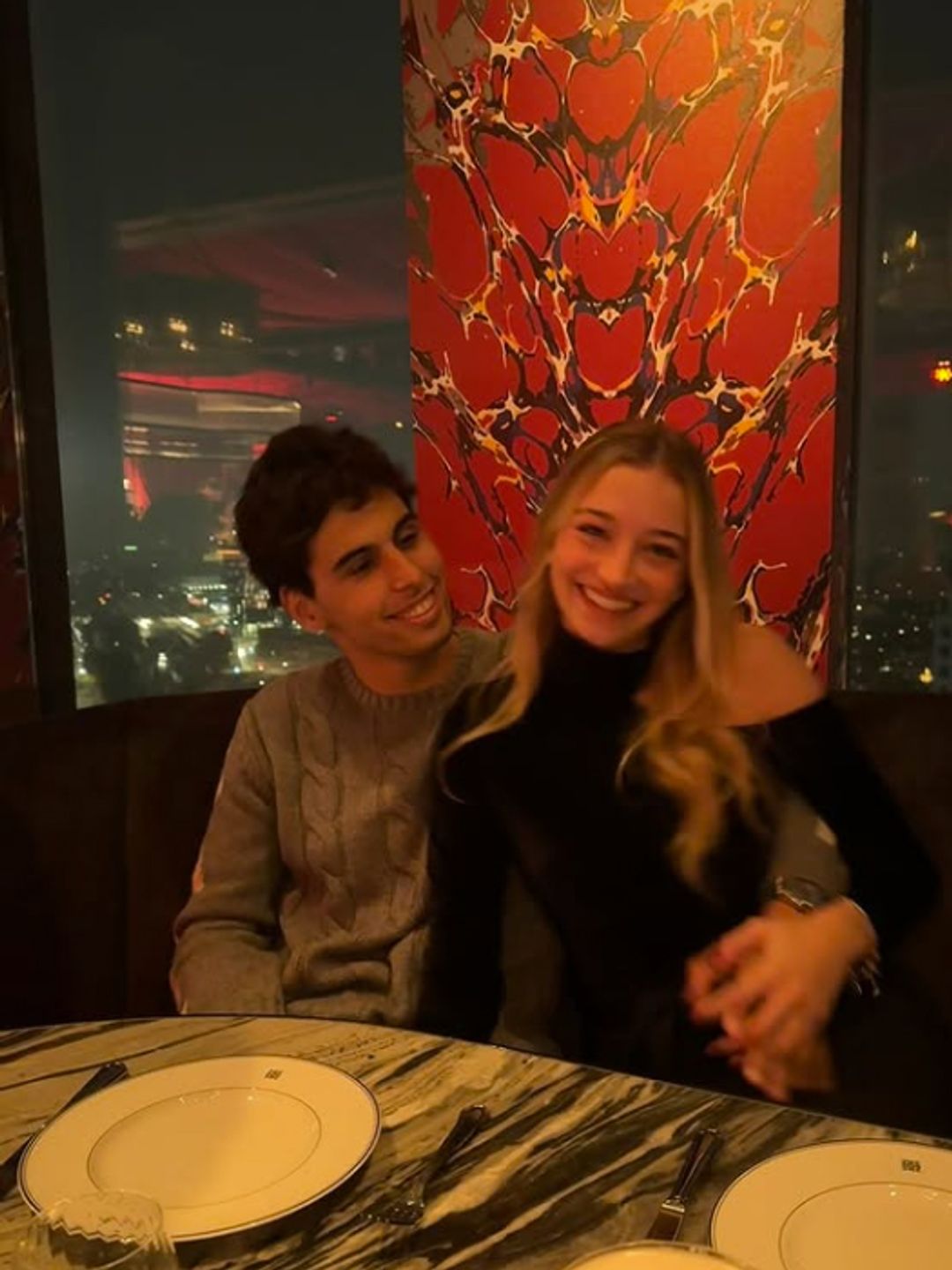 Gabriel Bortoleto sitting in a restaurant with Isabella Bernardini, his arm is around her