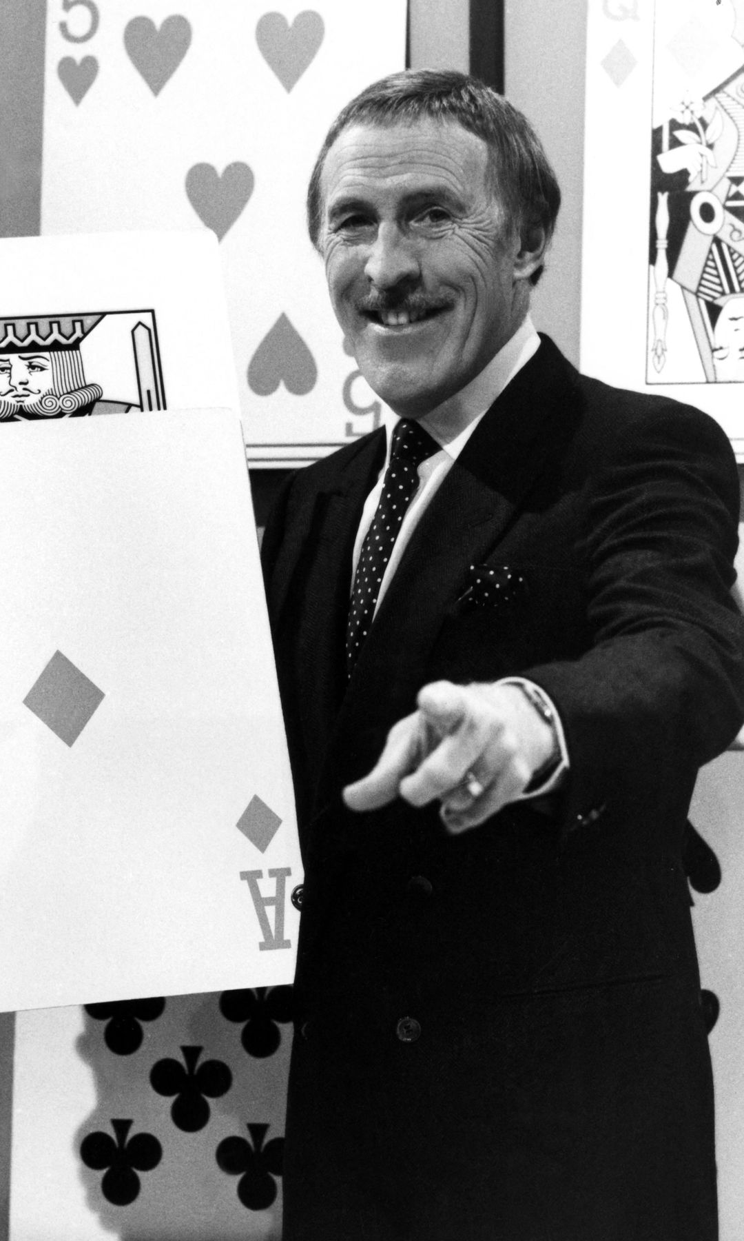 Image en noir et blanc de Bruce Forsyth présentant sur Play Your Cards Right